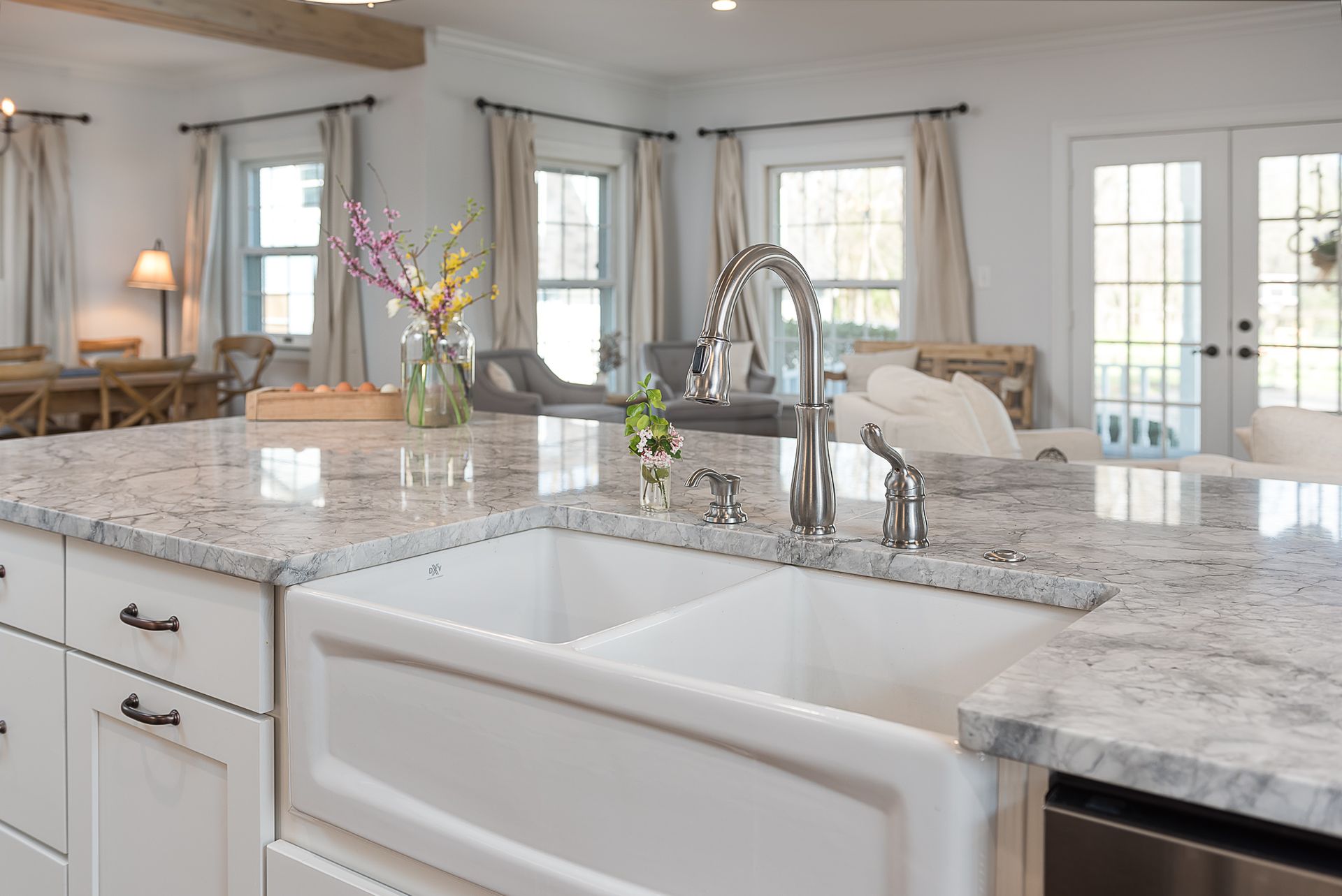 A kitchen with a white sink and granite counter tops.