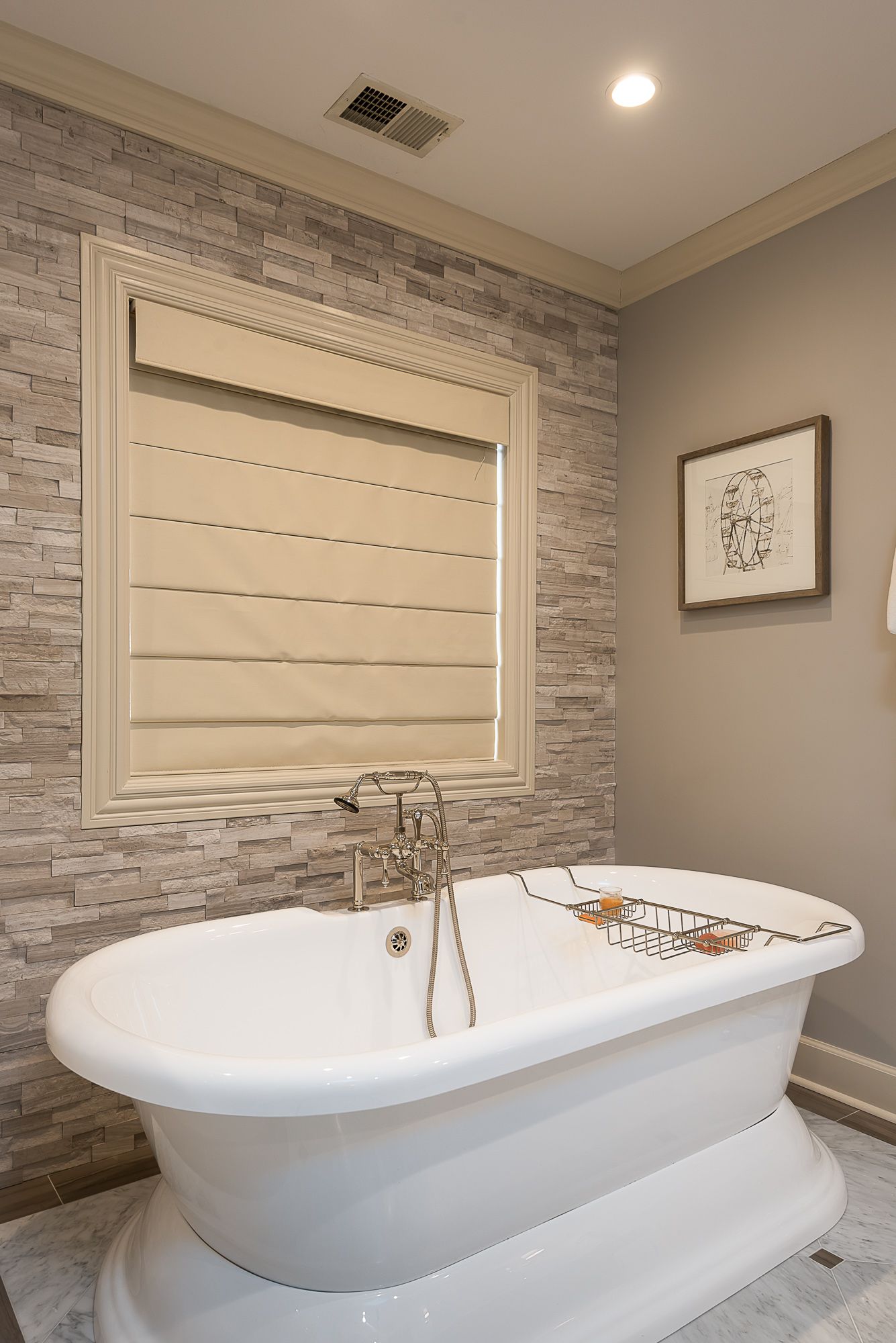 A bathtub in a bathroom with a brick wall and a window.