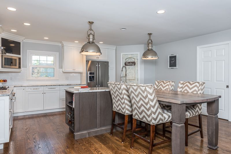 A kitchen with a table and chairs and a refrigerator.