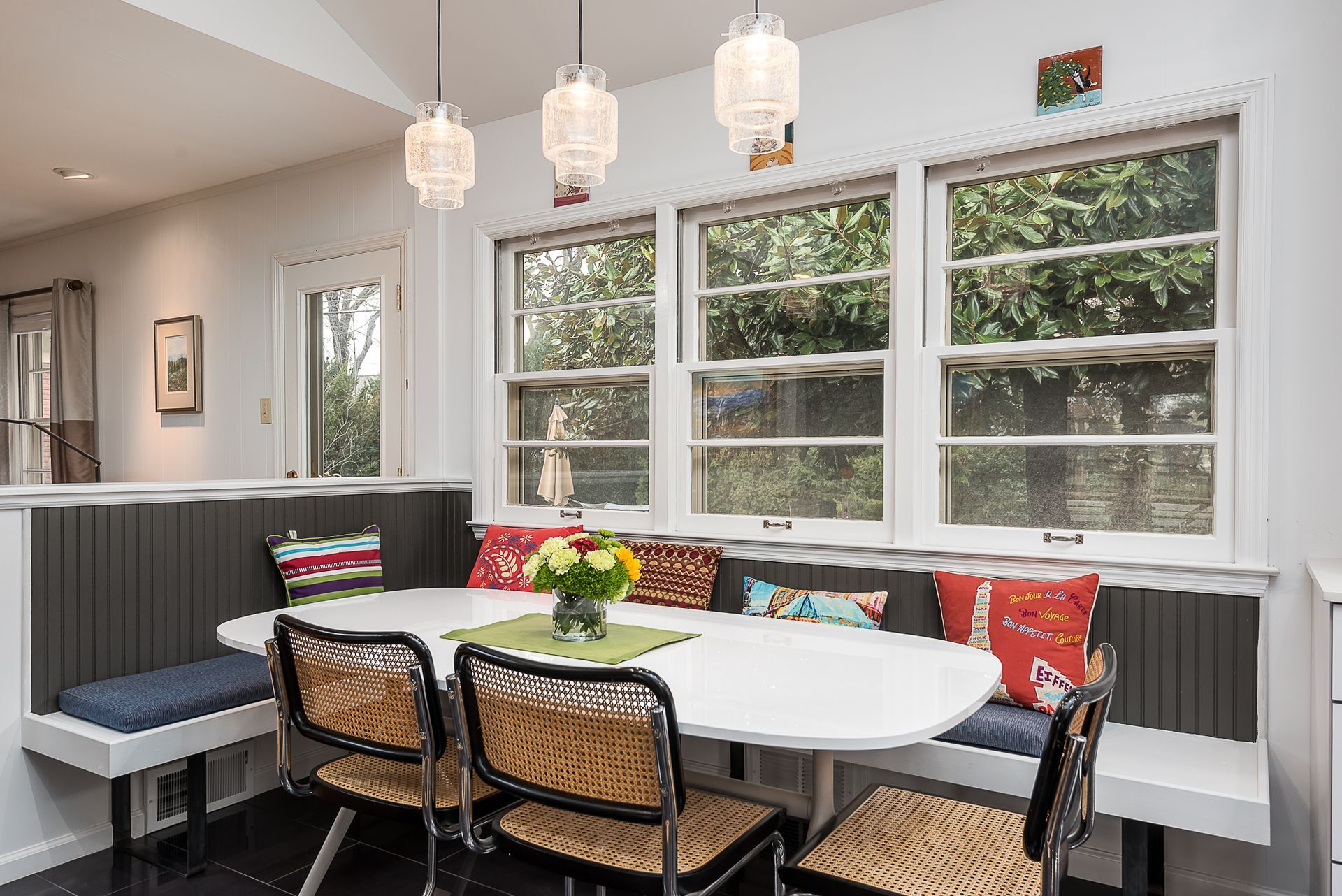 A dining room with a table and chairs and a bench.