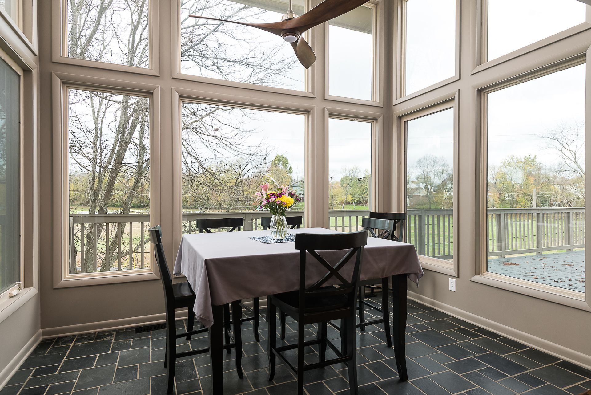 A dining room with a table and chairs and a ceiling fan