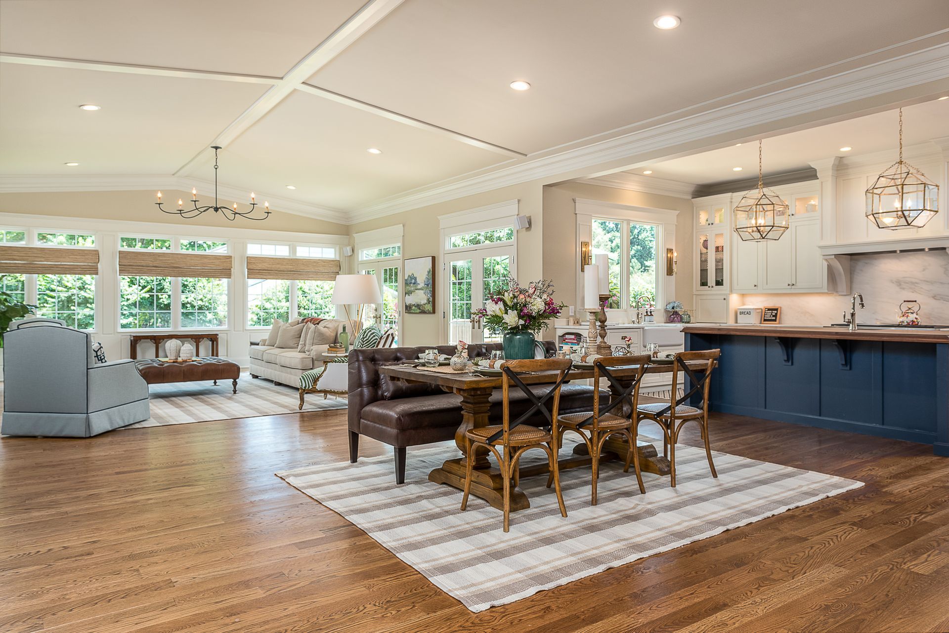 A living room with a dining room table and chairs and a kitchen.