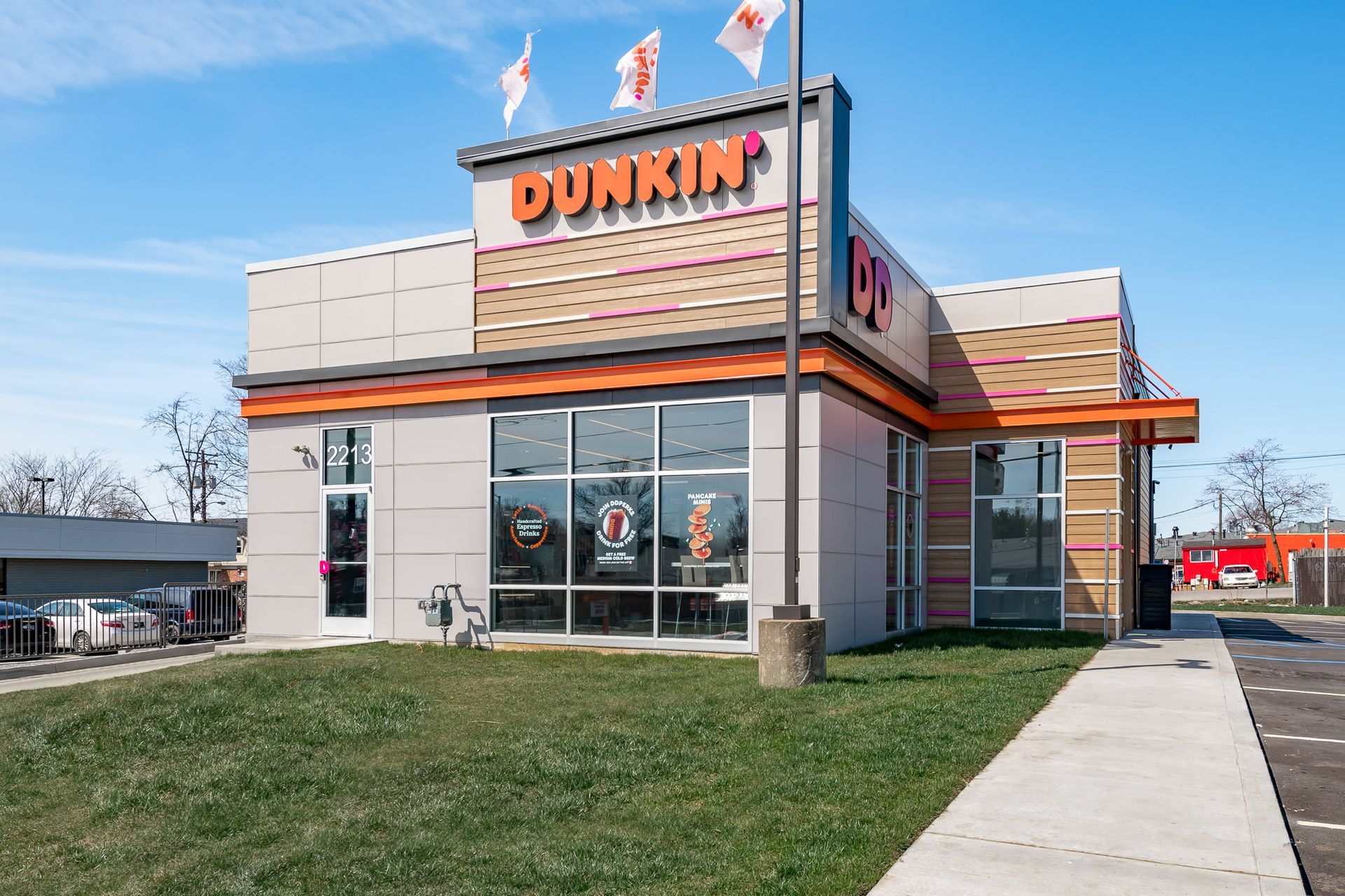 A dunkin ' donuts restaurant with a sidewalk in front of it