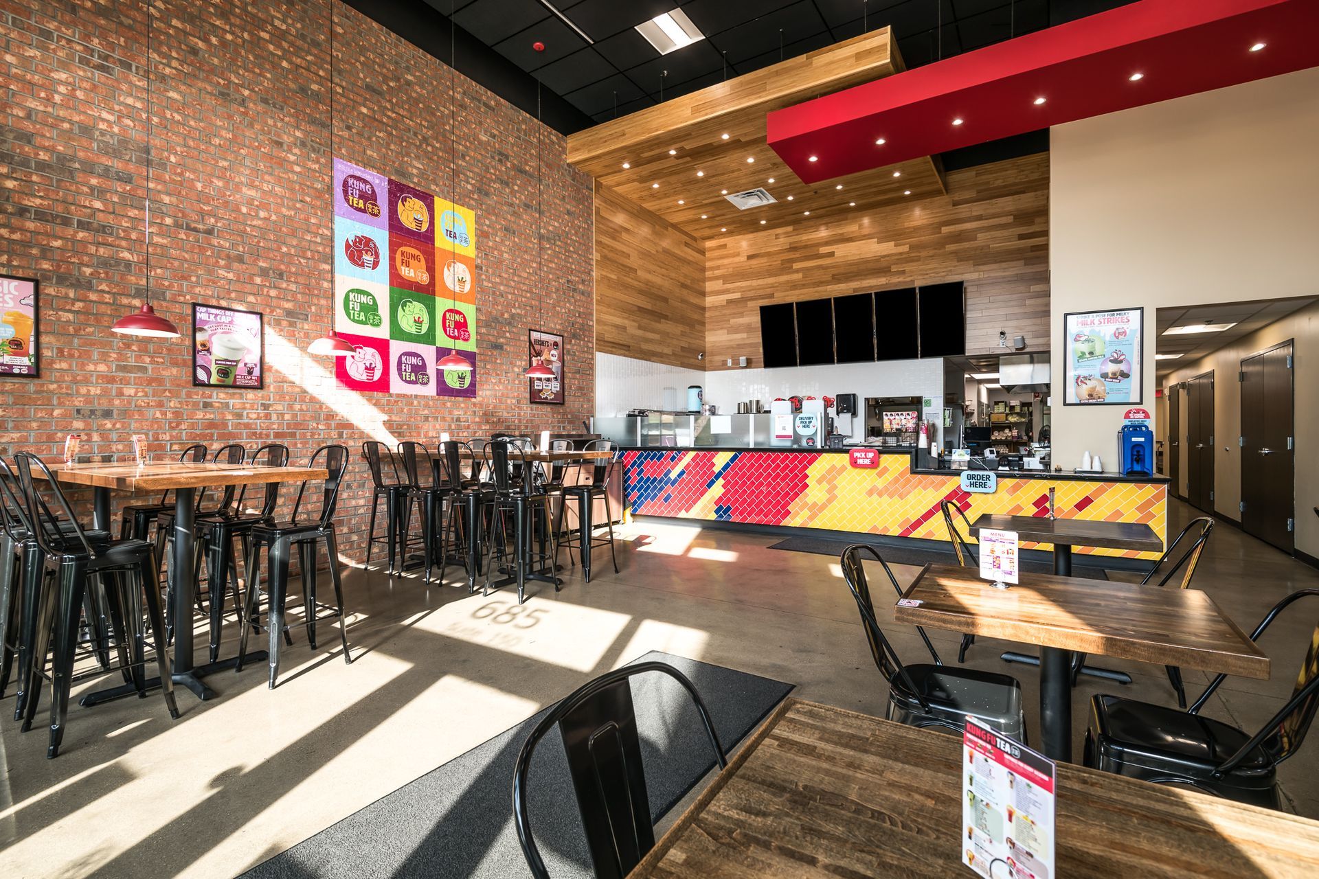 A restaurant with tables and chairs and a counter.