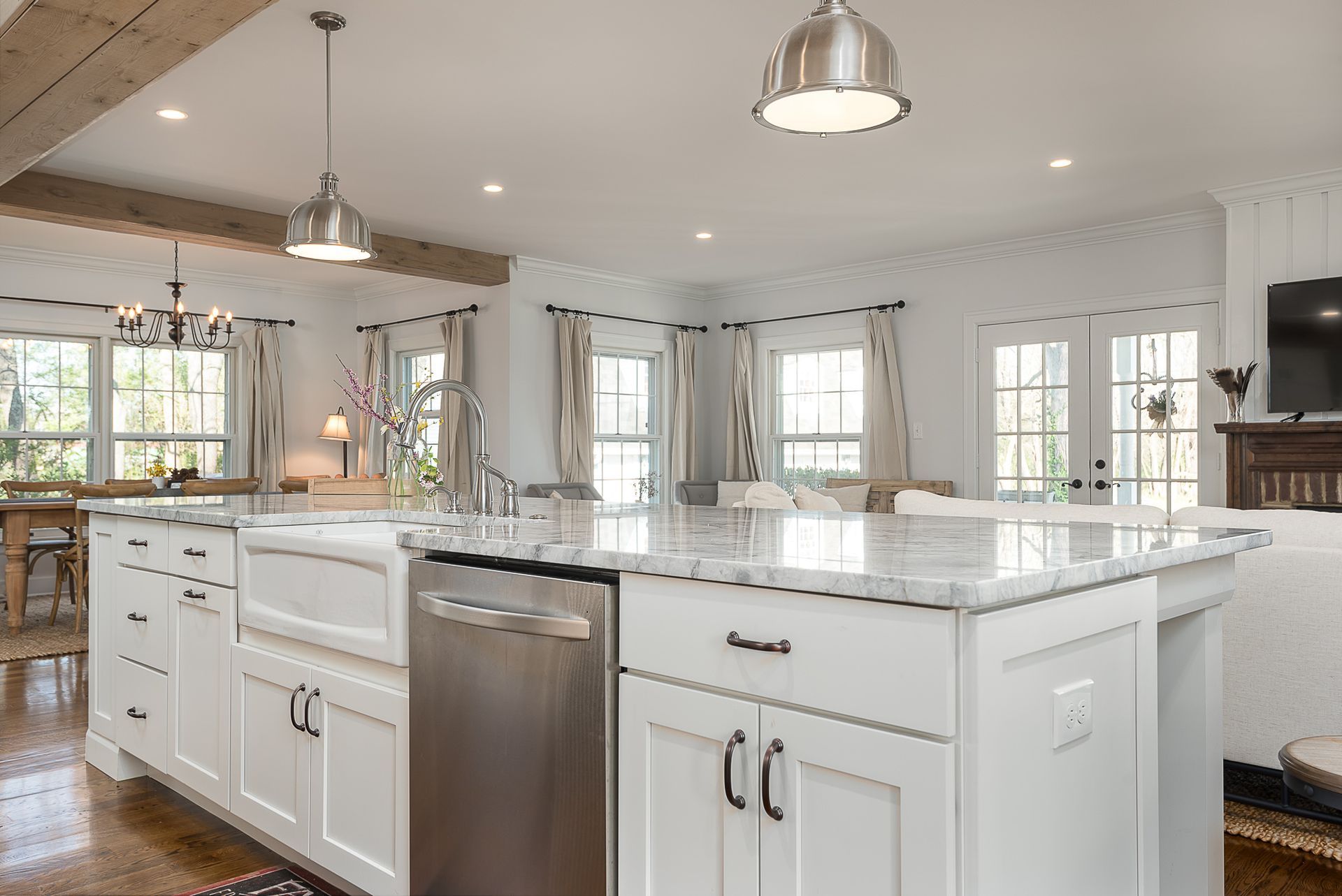 A kitchen with white cabinets , granite counter tops , stainless steel appliances and a large island.