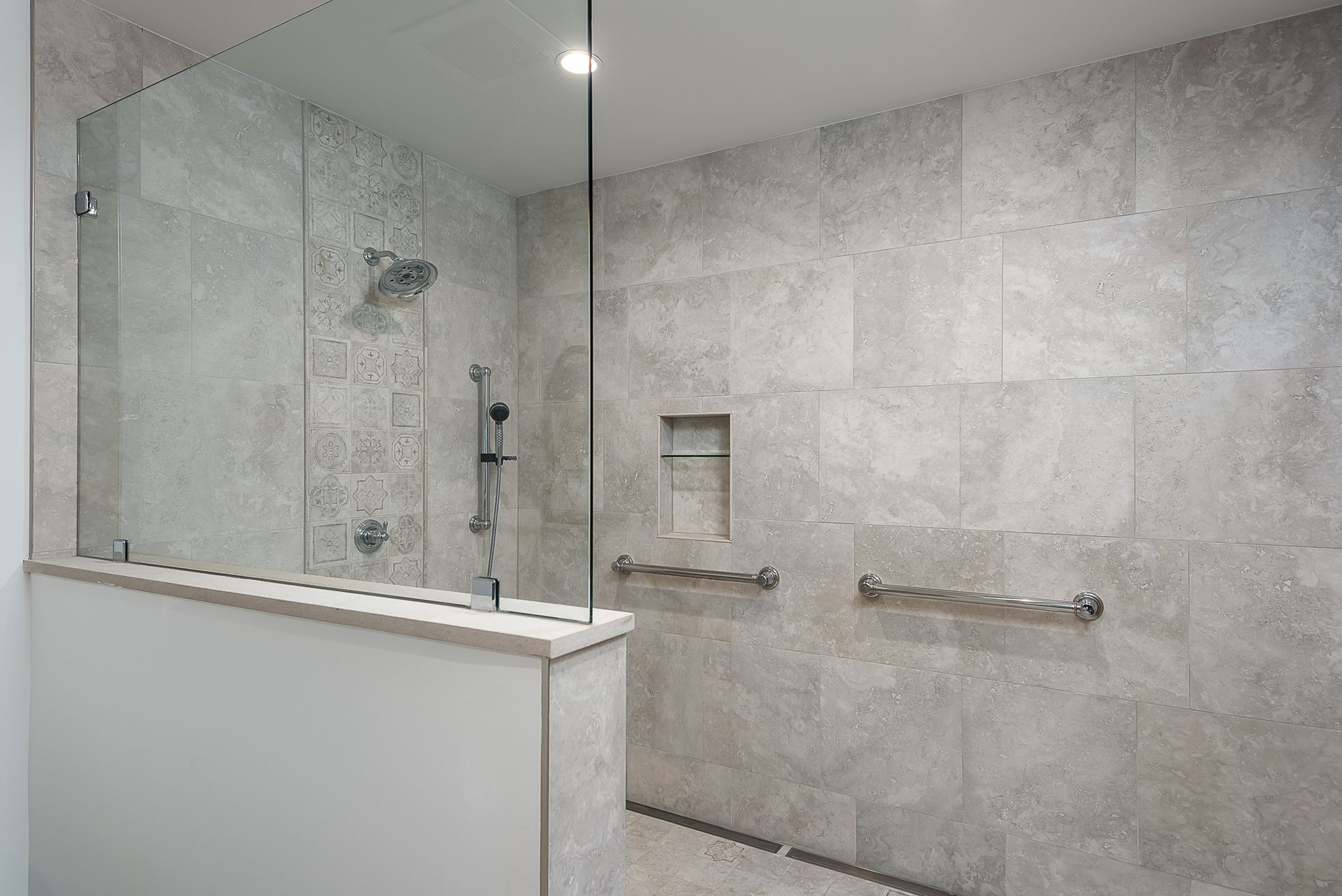 A bathroom with a walk in shower with a glass door.