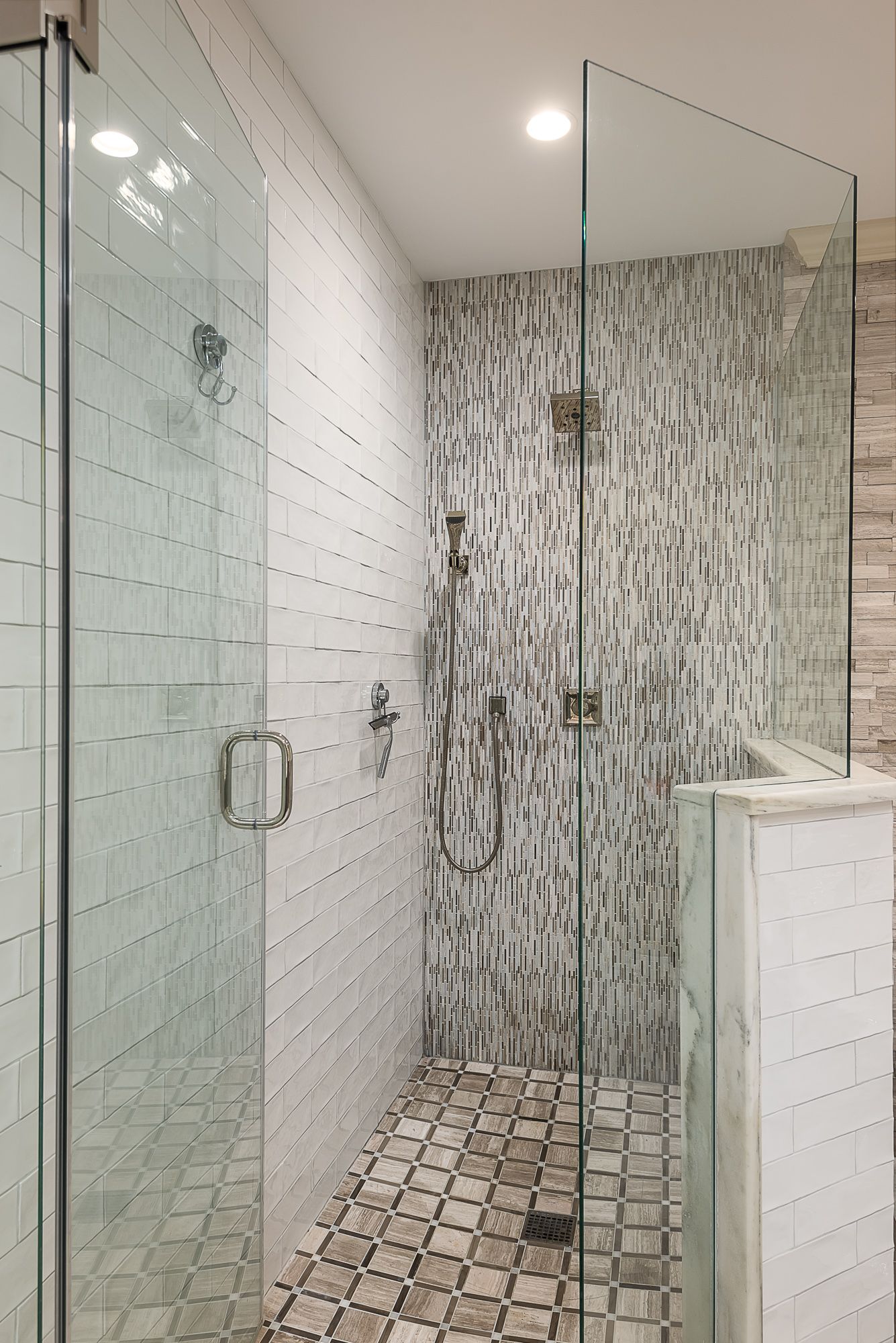 A bathroom with a walk in shower with a glass door.