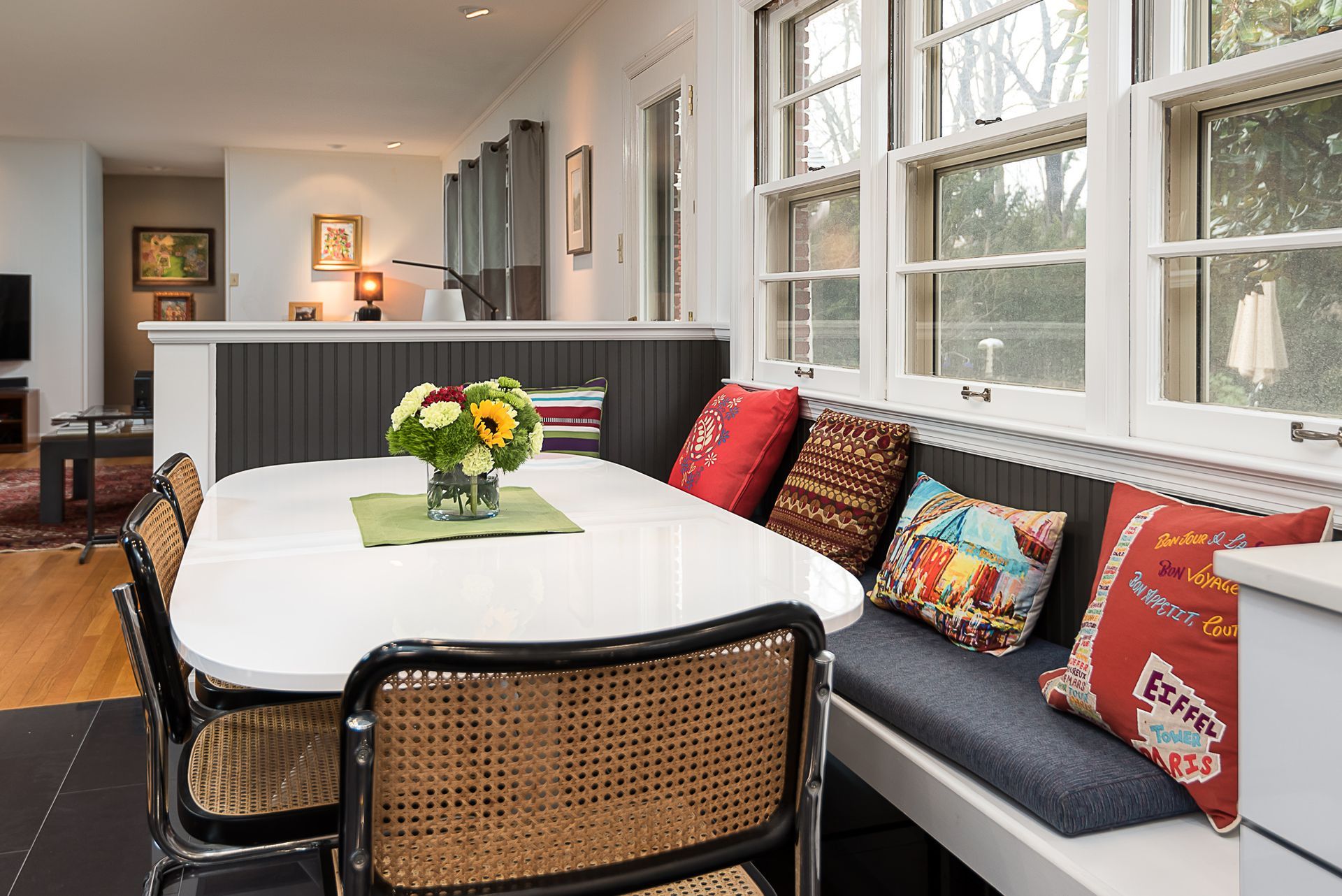 A dining room with a table and chairs and a bench.