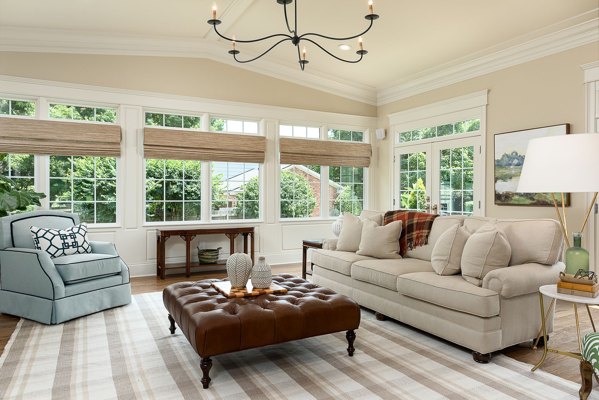 A living room with a couch , chair , coffee table and ottoman.