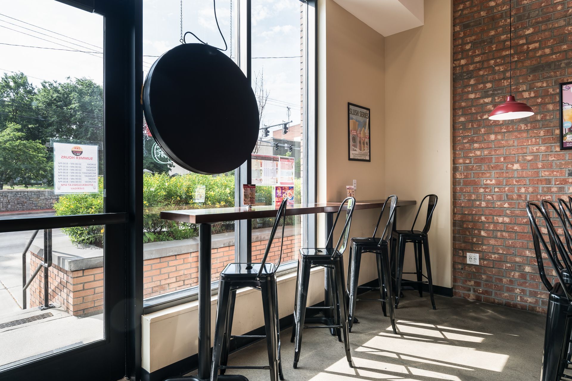 A restaurant with tables and chairs and a brick wall.