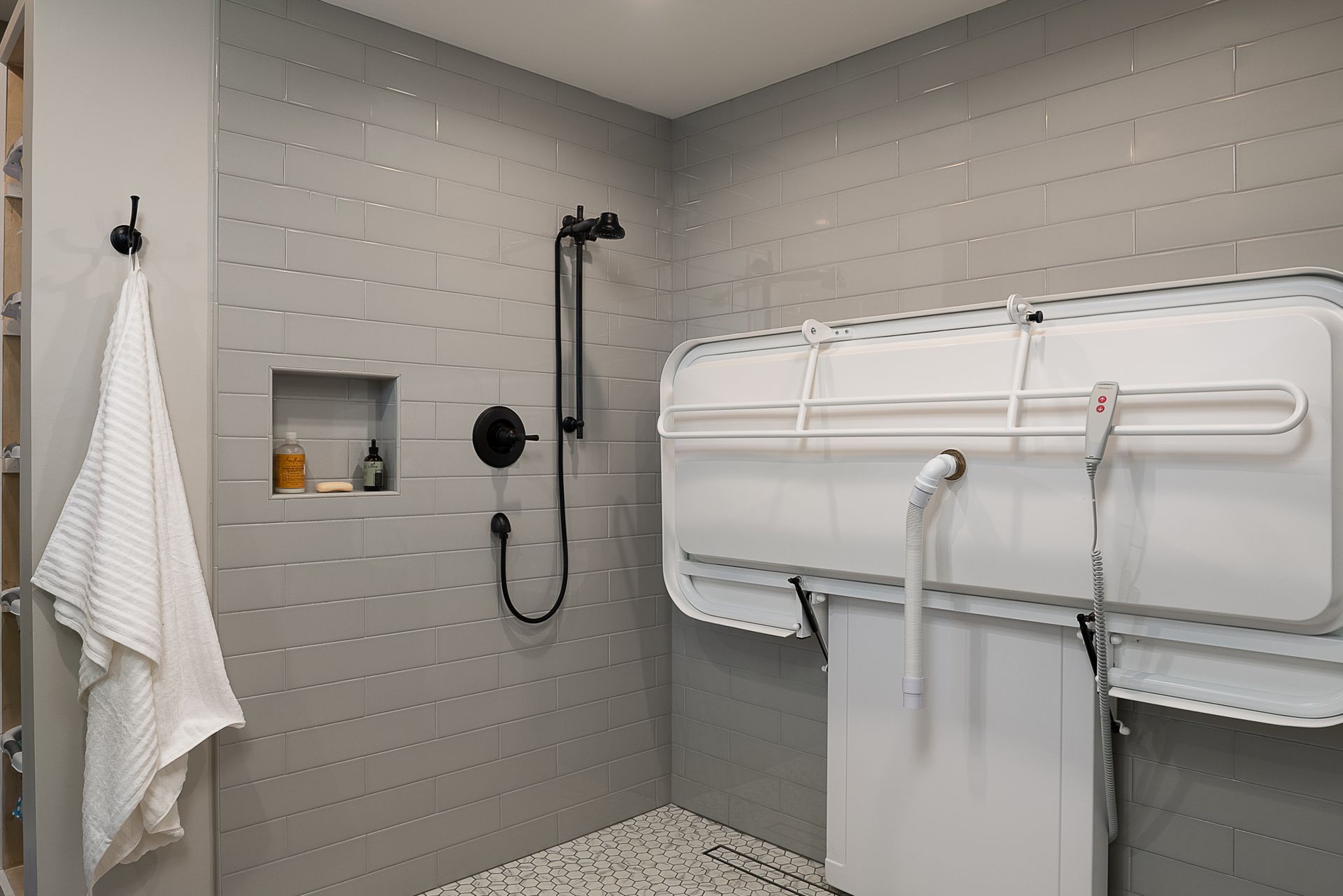 A bathroom with a walk in shower and a changing table.