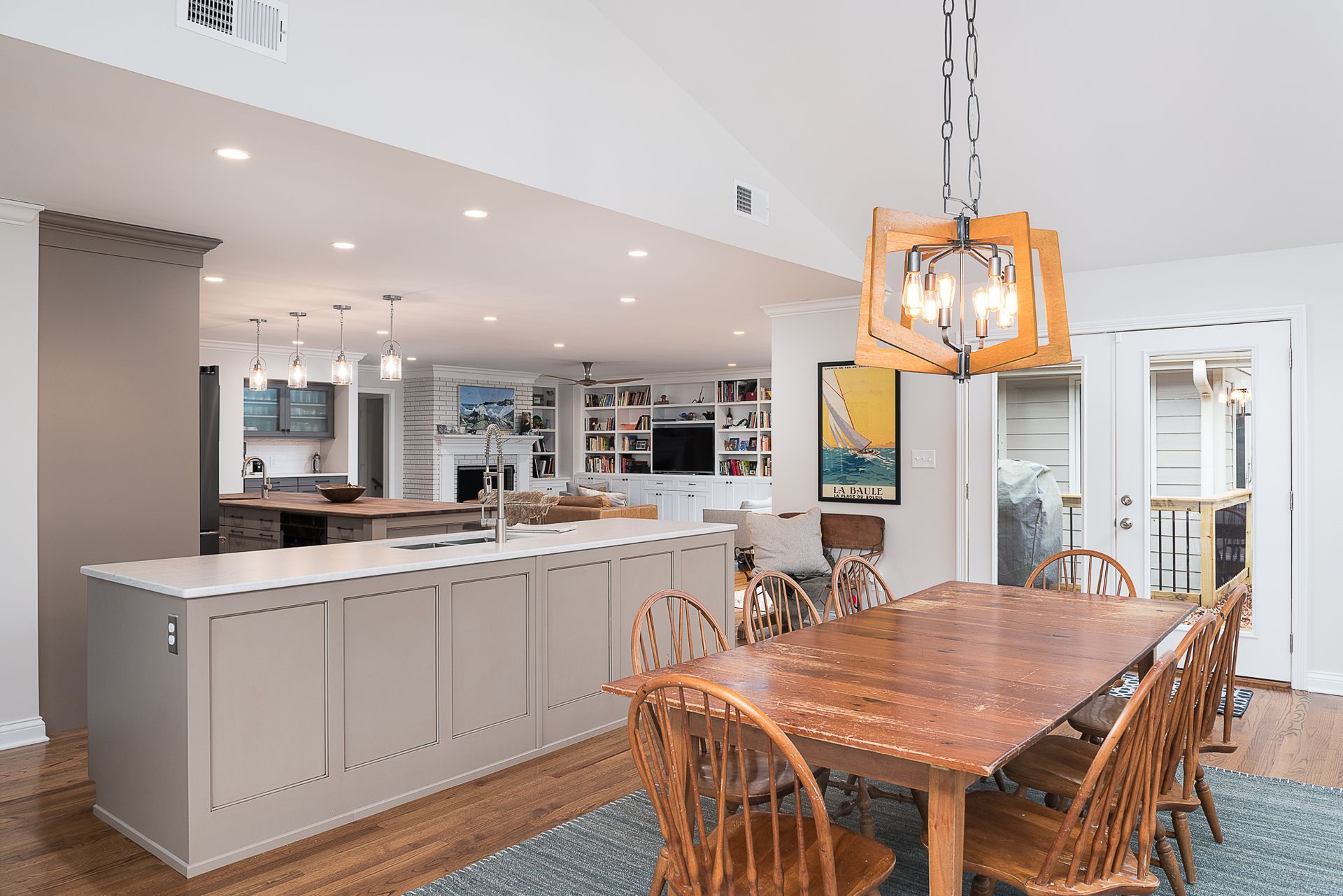 A dining room table and chairs in a kitchen with a chandelier hanging from the ceiling.