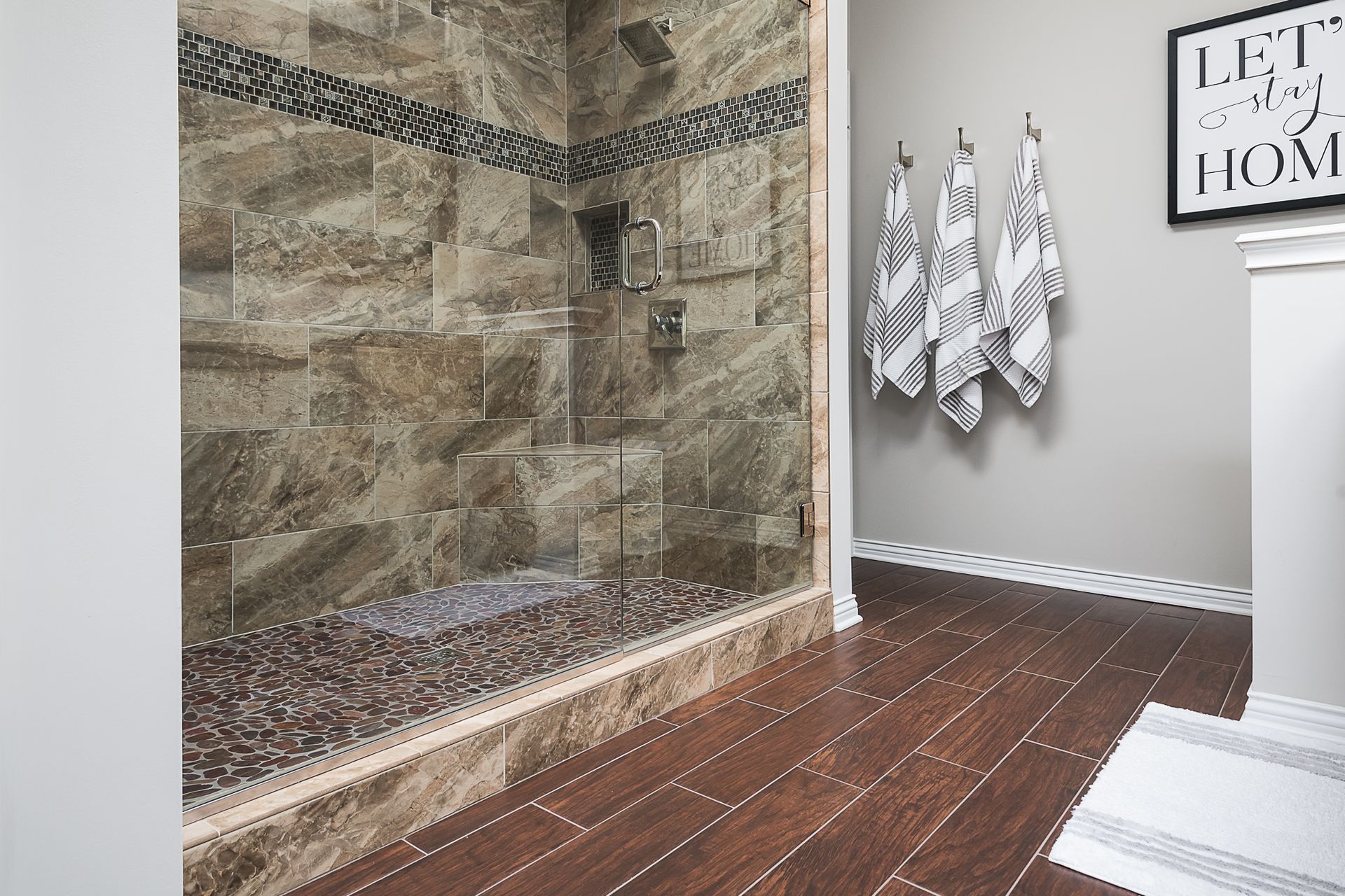 A bathroom with a walk in shower and a sign that says let 's go home.