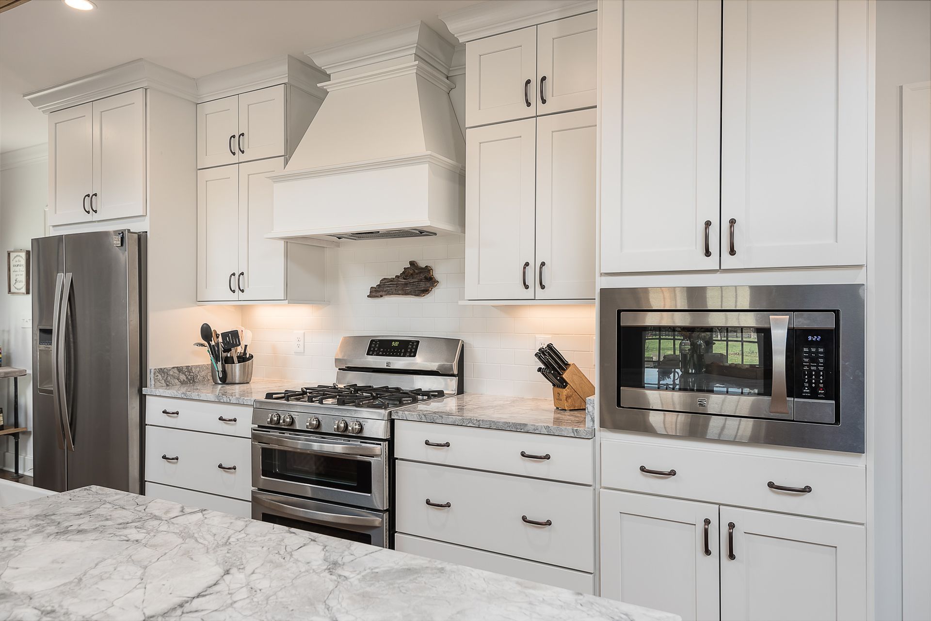 A kitchen with white cabinets and stainless steel appliances.