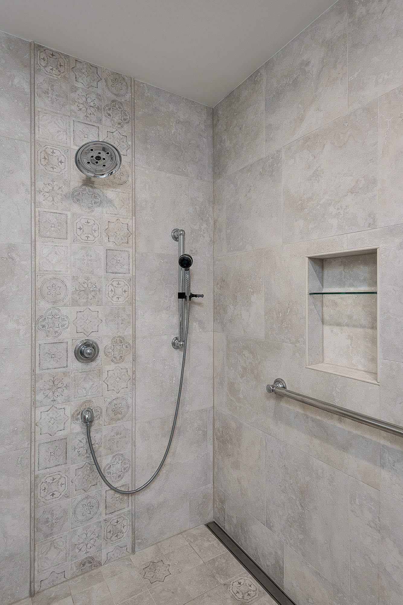 A walk in shower with a chain attached to the shower head.