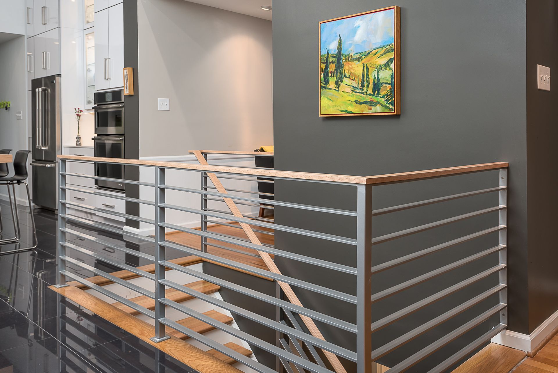 There is a painting on the wall above the stairs.