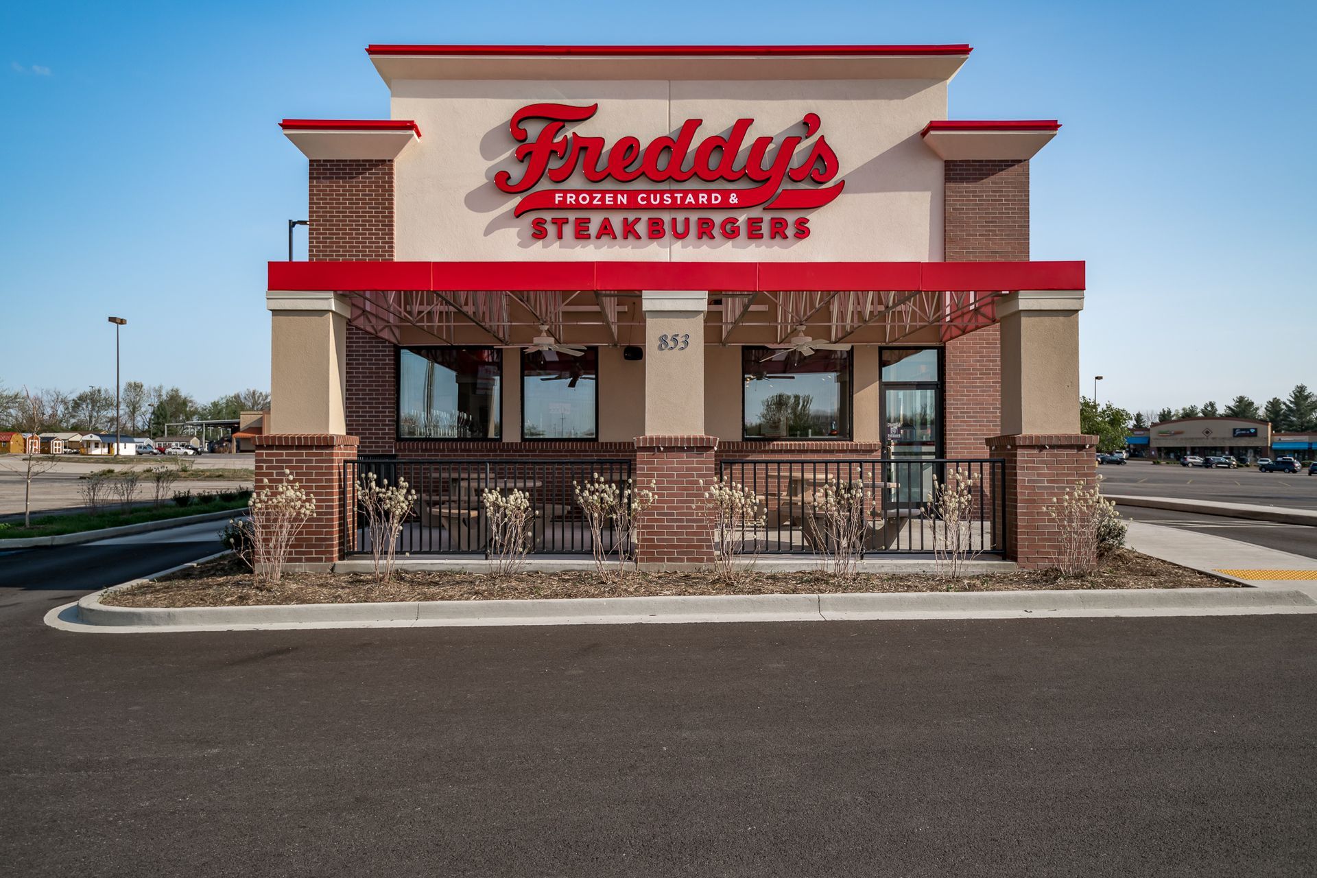 A freddy 's steakburgers restaurant is located in a parking lot.