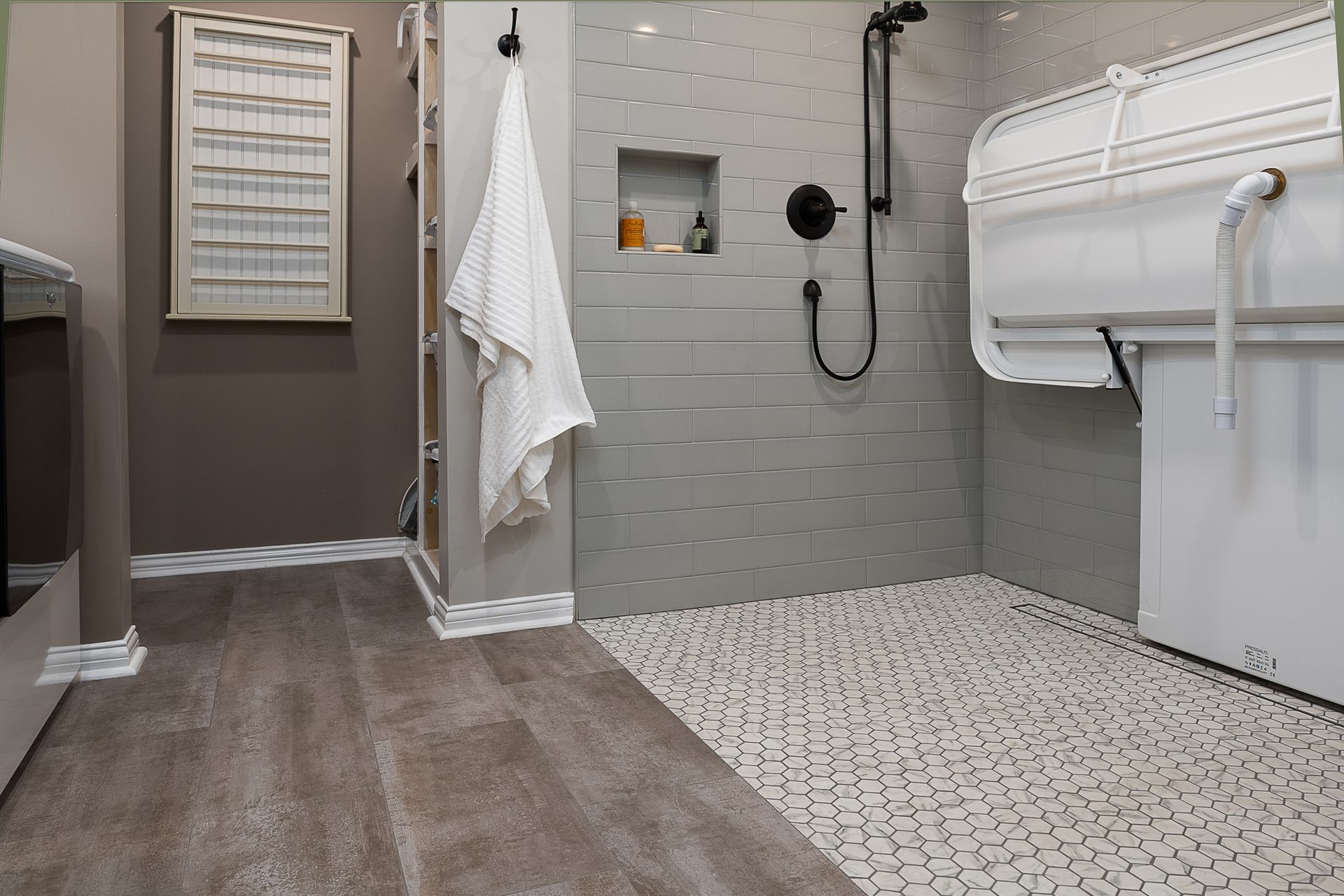 A bathroom with a walk in shower and a changing table.