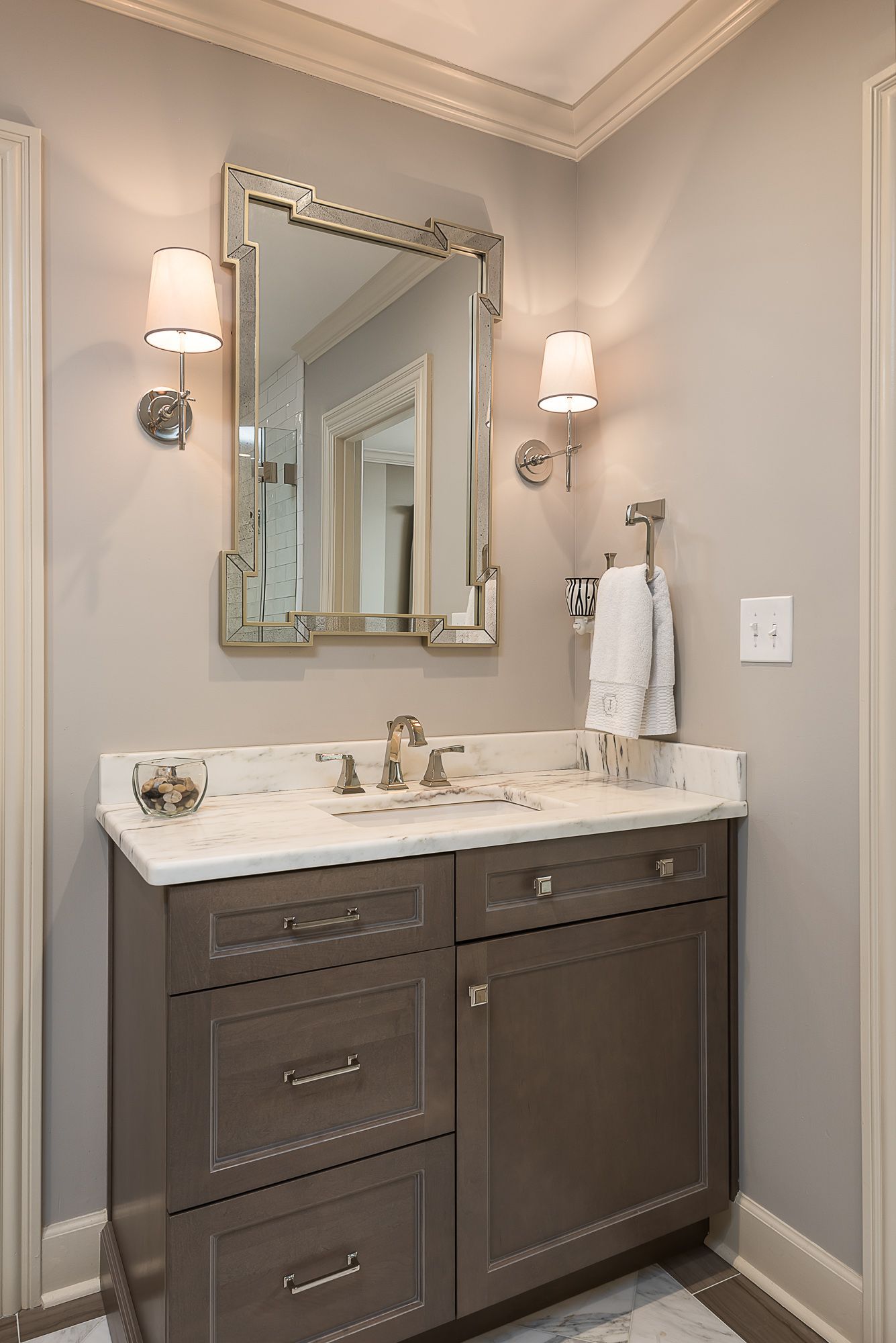 A bathroom with a sink , mirror and cabinets.