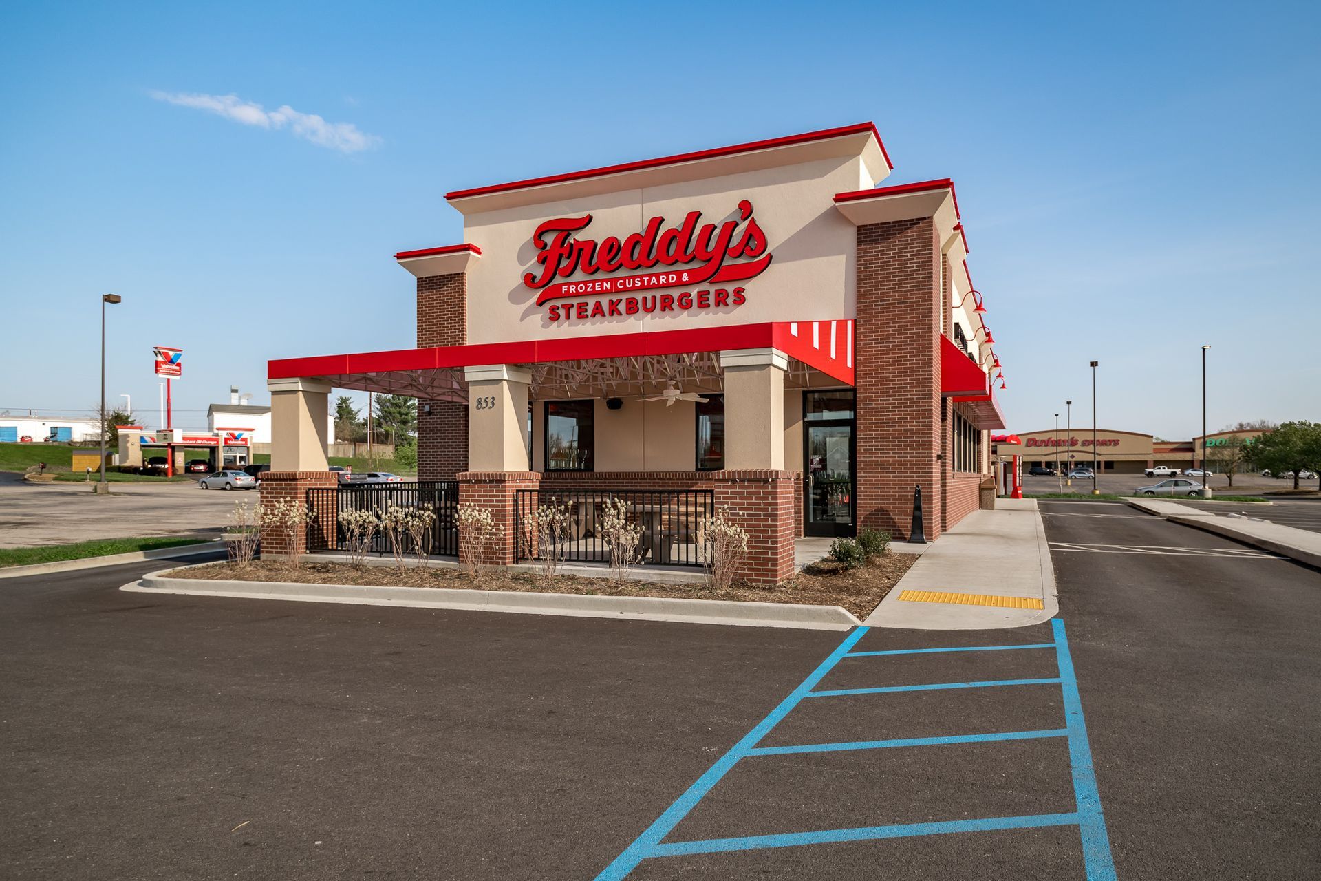 A freddy 's restaurant with a parking lot in front of it