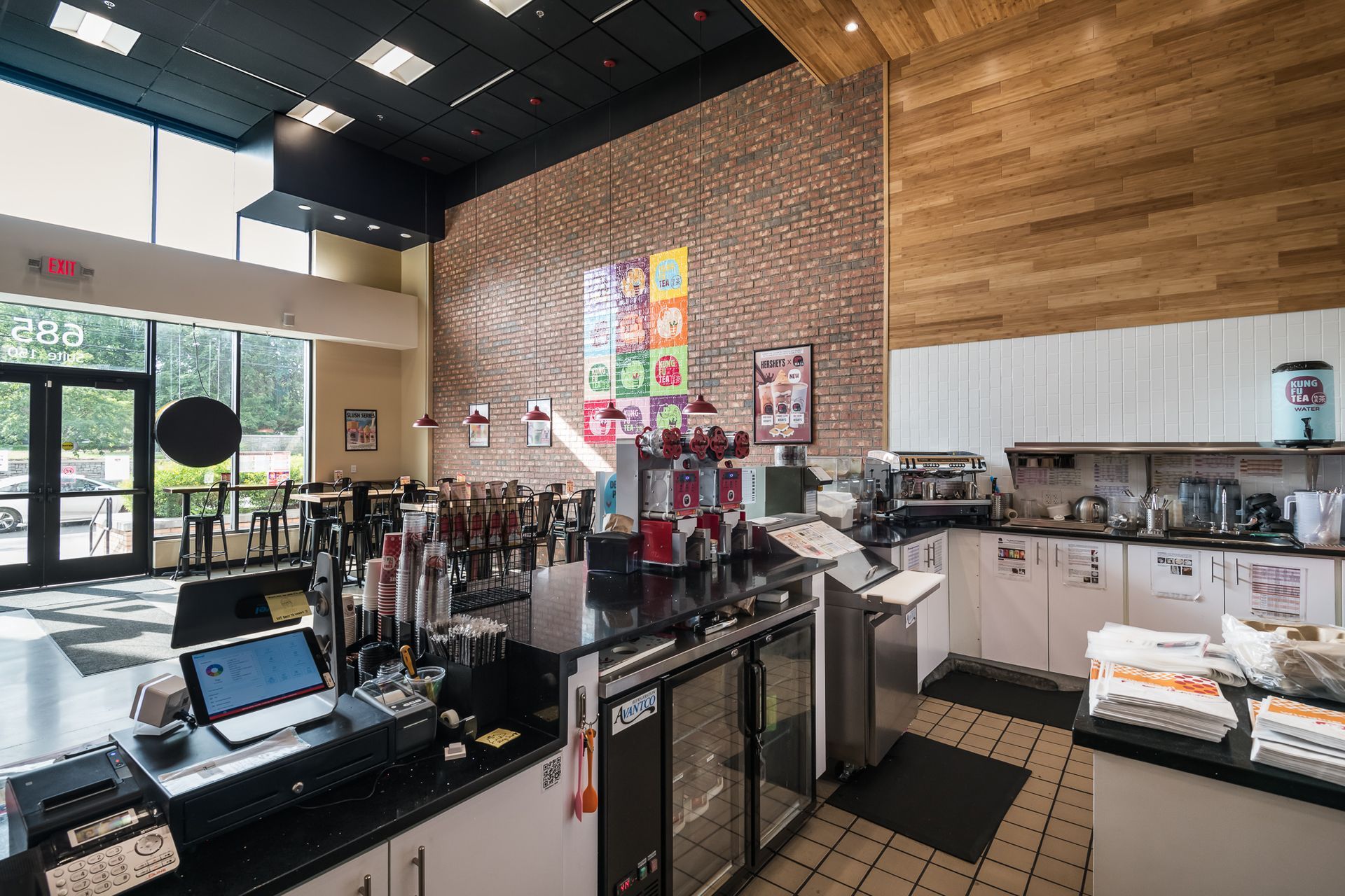 A kitchen in a restaurant with a laptop on the counter.