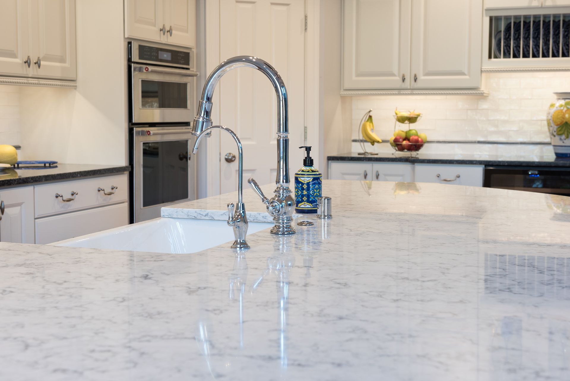 A kitchen with a sink and a soap dispenser on the counter.