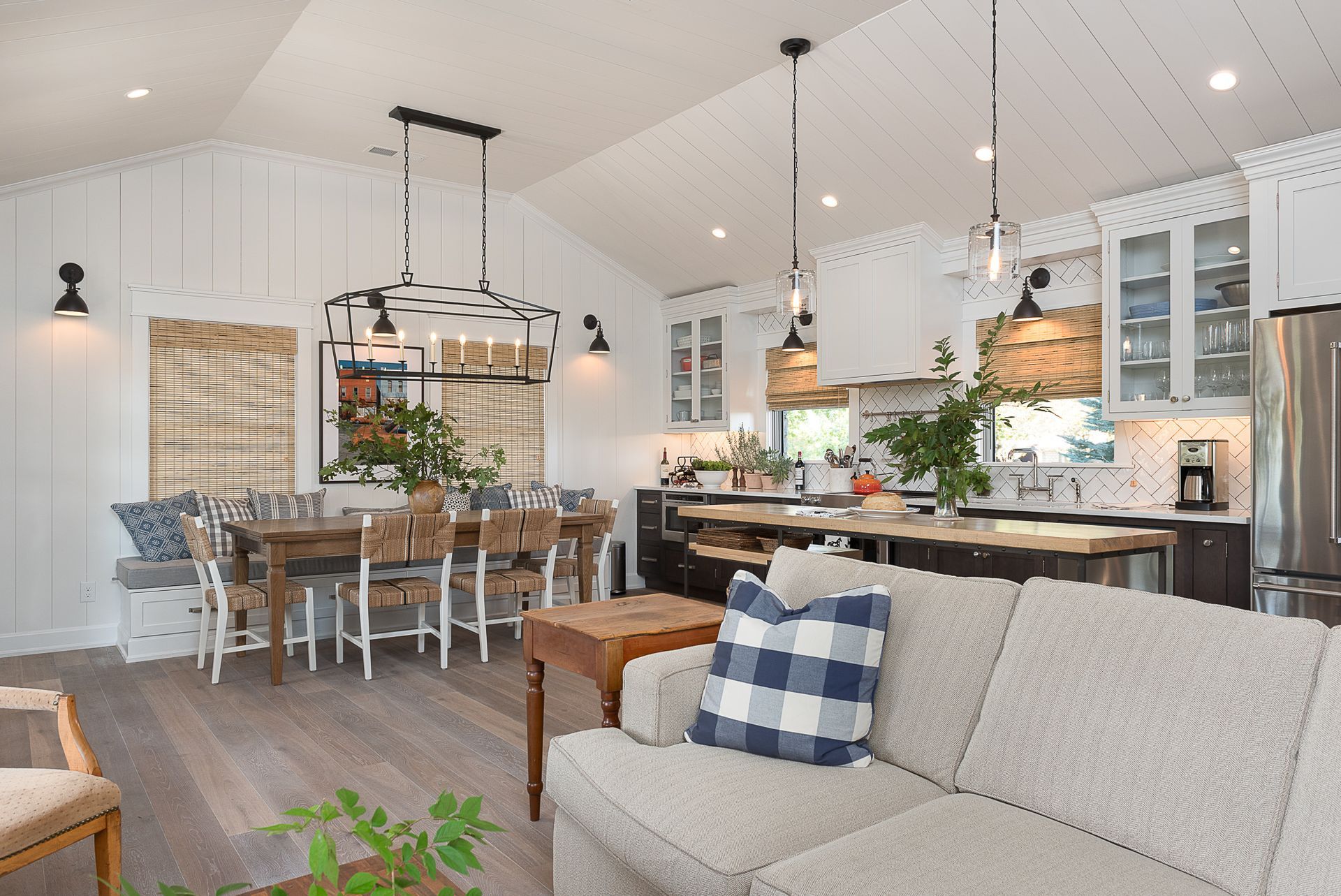 A living room with a couch , table , chairs and a kitchen.