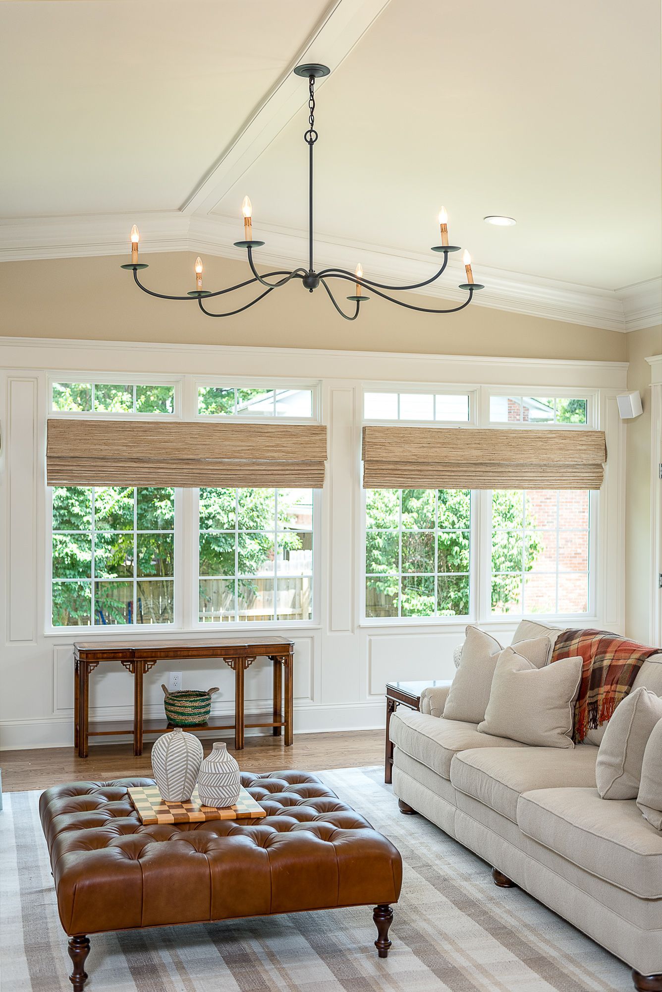 A living room with a couch , coffee table , and chandelier.