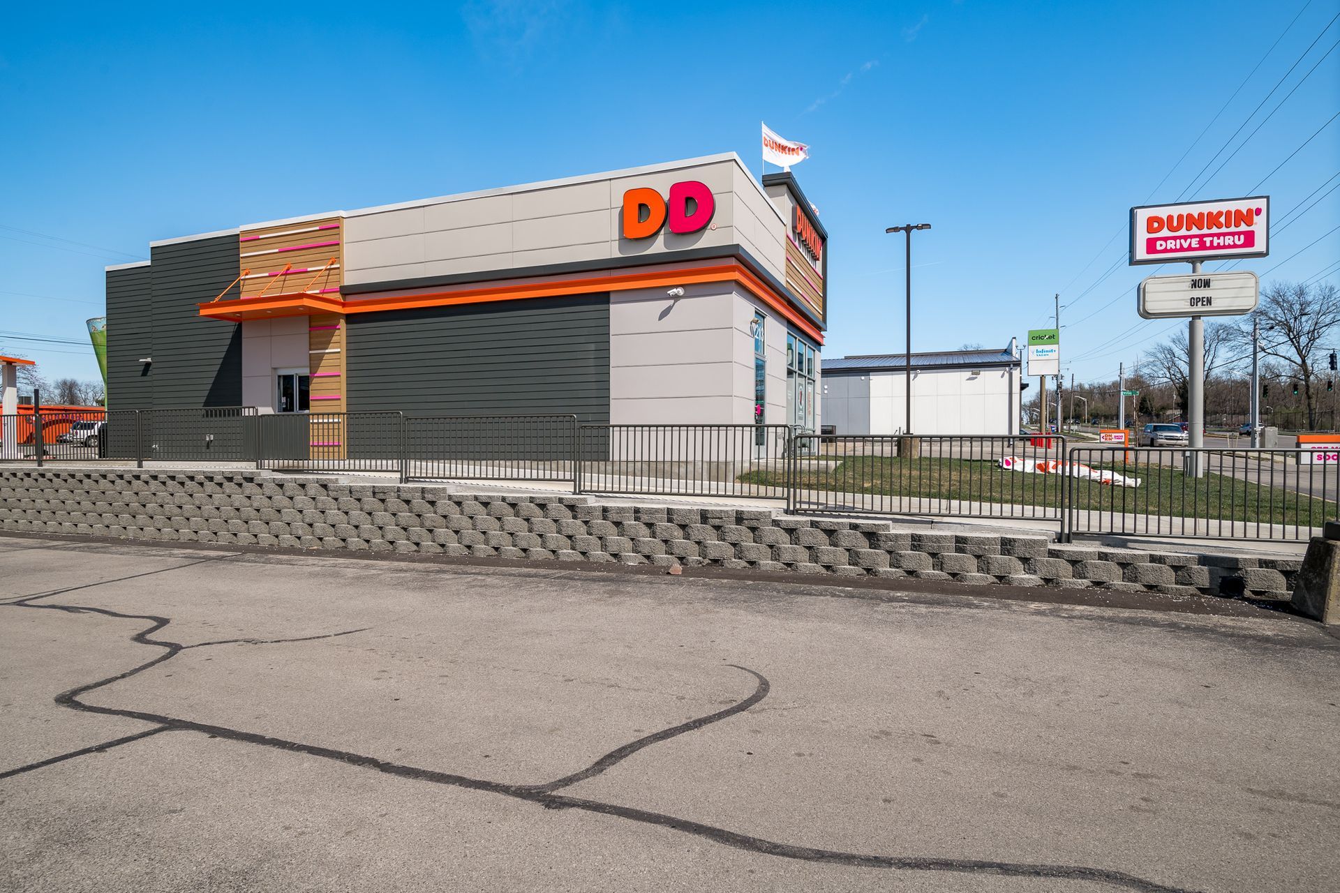 A dunkin donuts restaurant is sitting on the side of the road