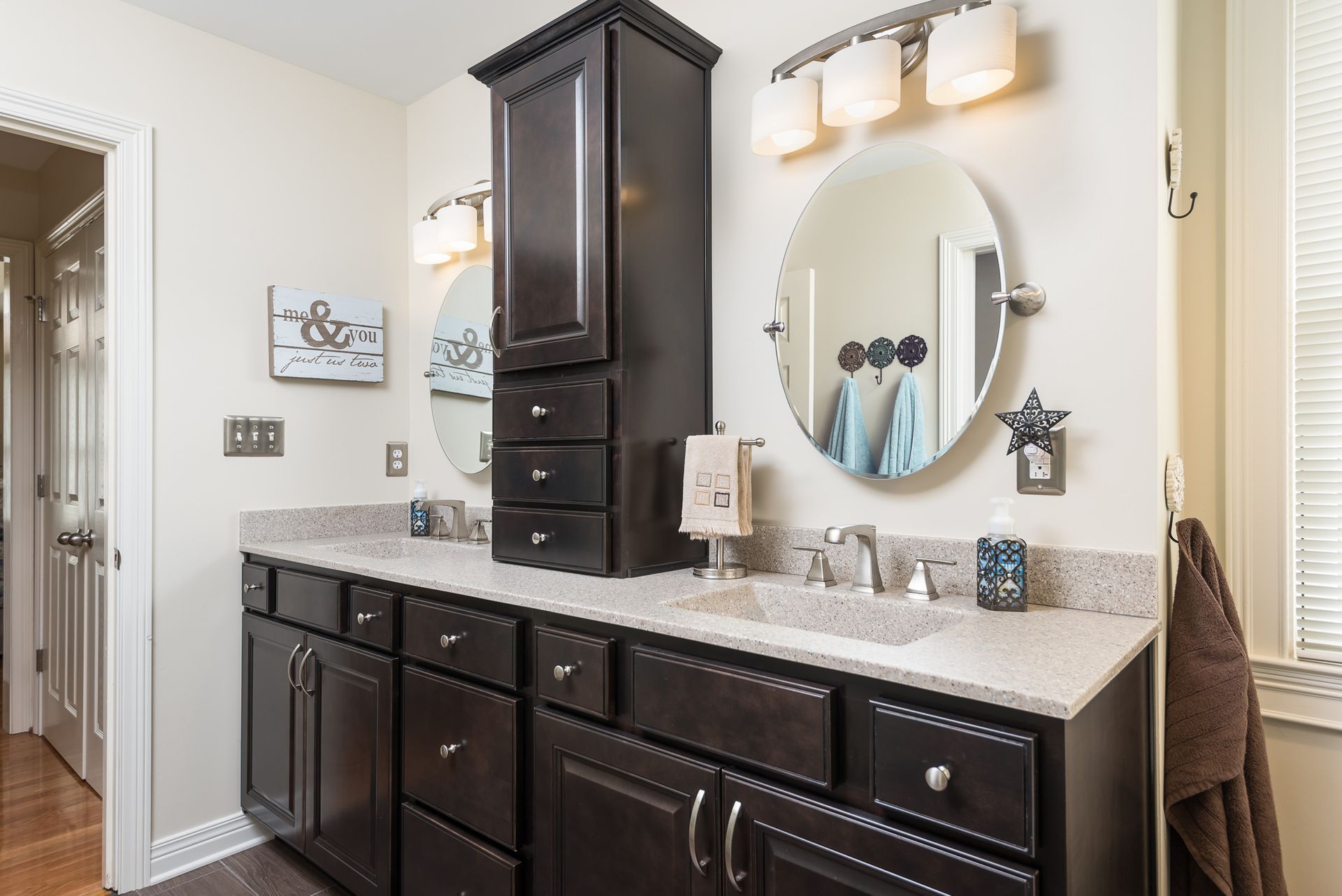 A bathroom with two sinks and a round mirror.