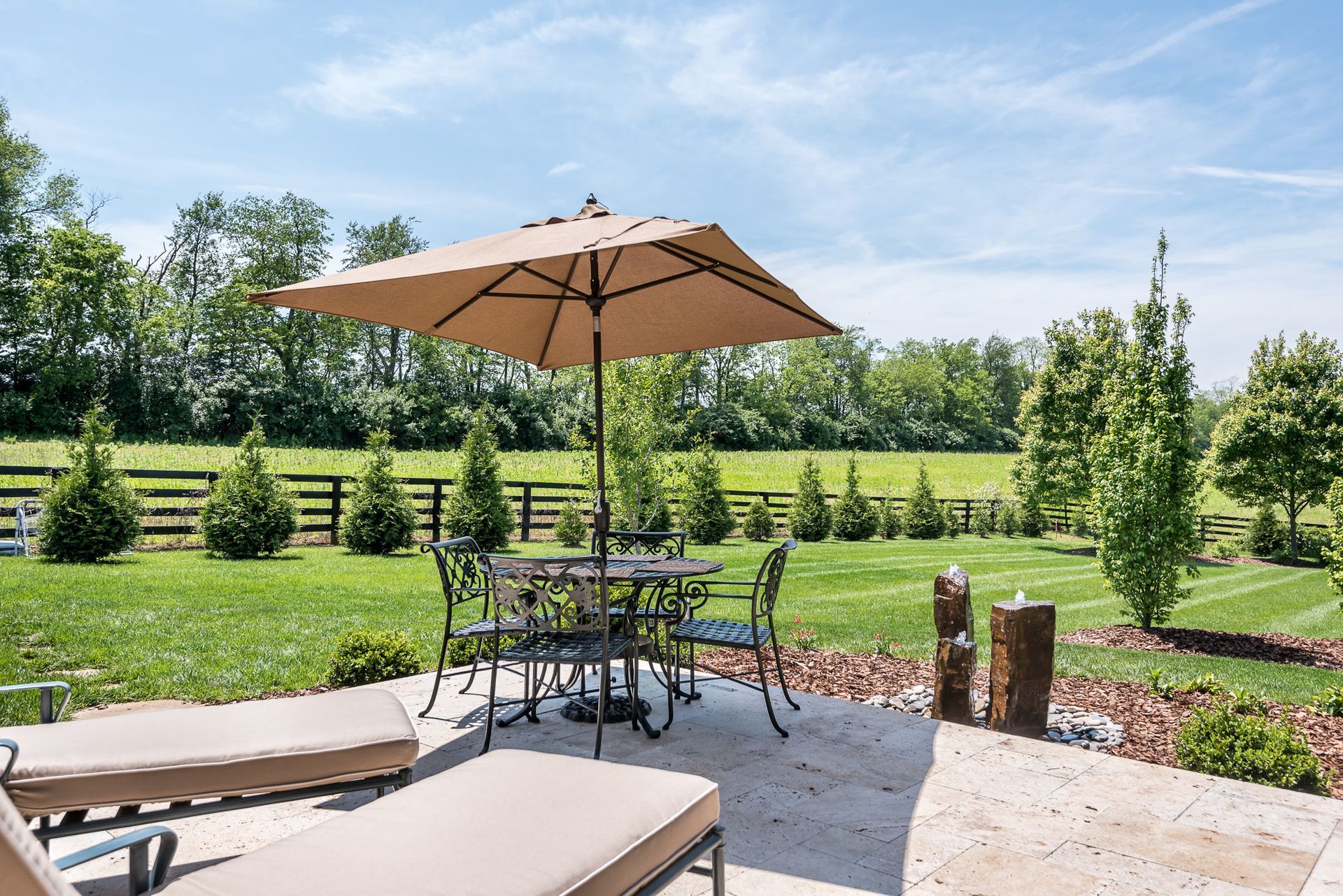 A patio with a table and chairs and an umbrella