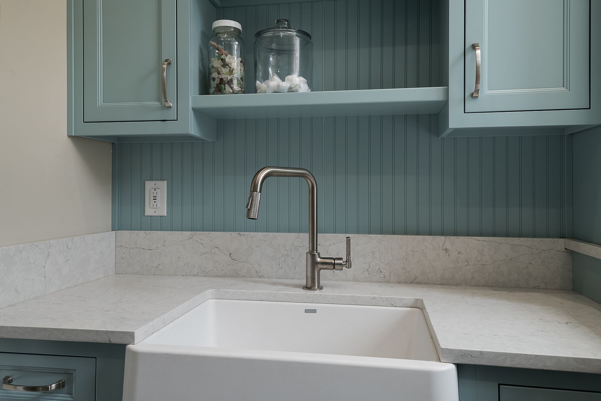 A kitchen with blue cabinets and a white sink