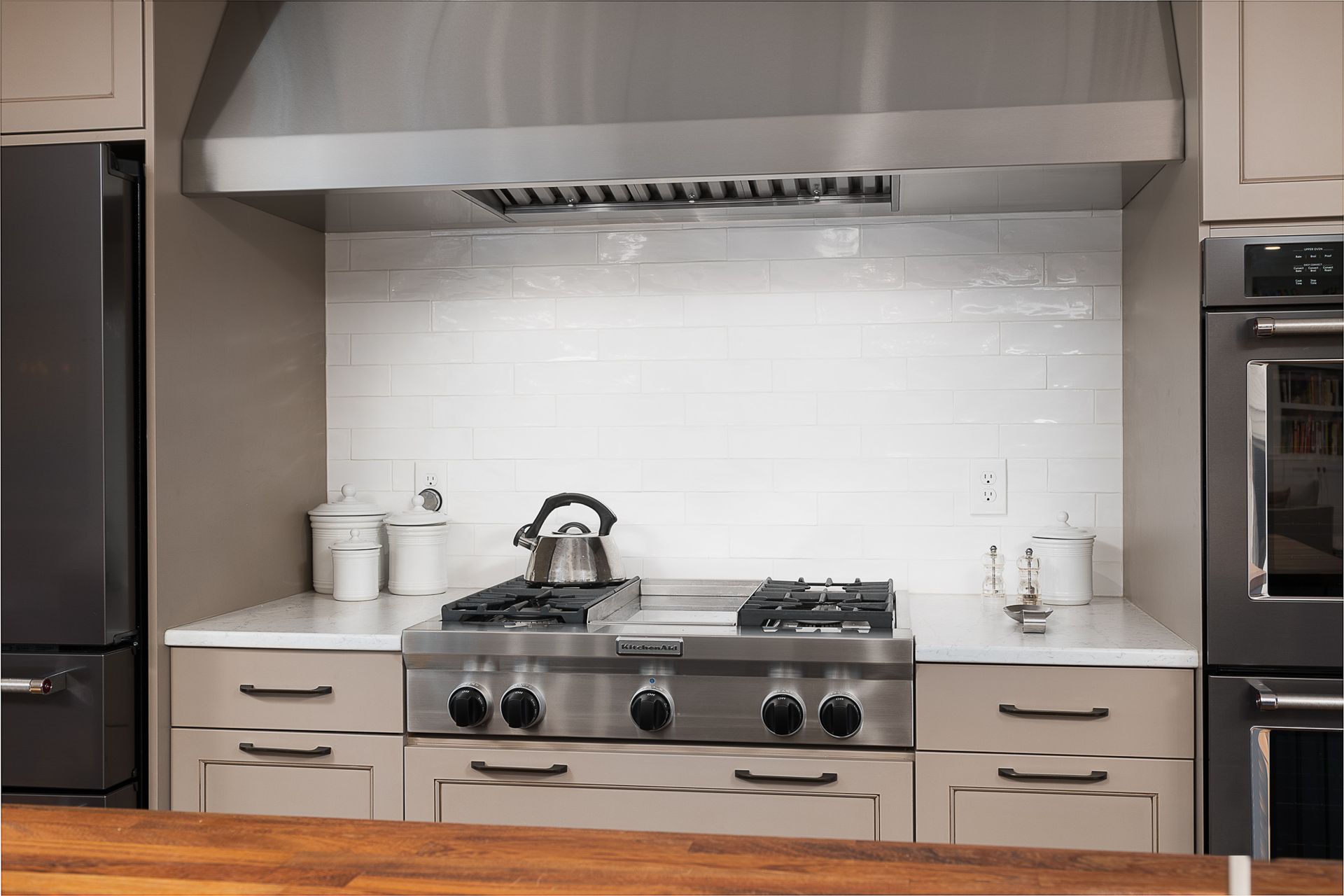 A kitchen with a stove , refrigerator , and oven.