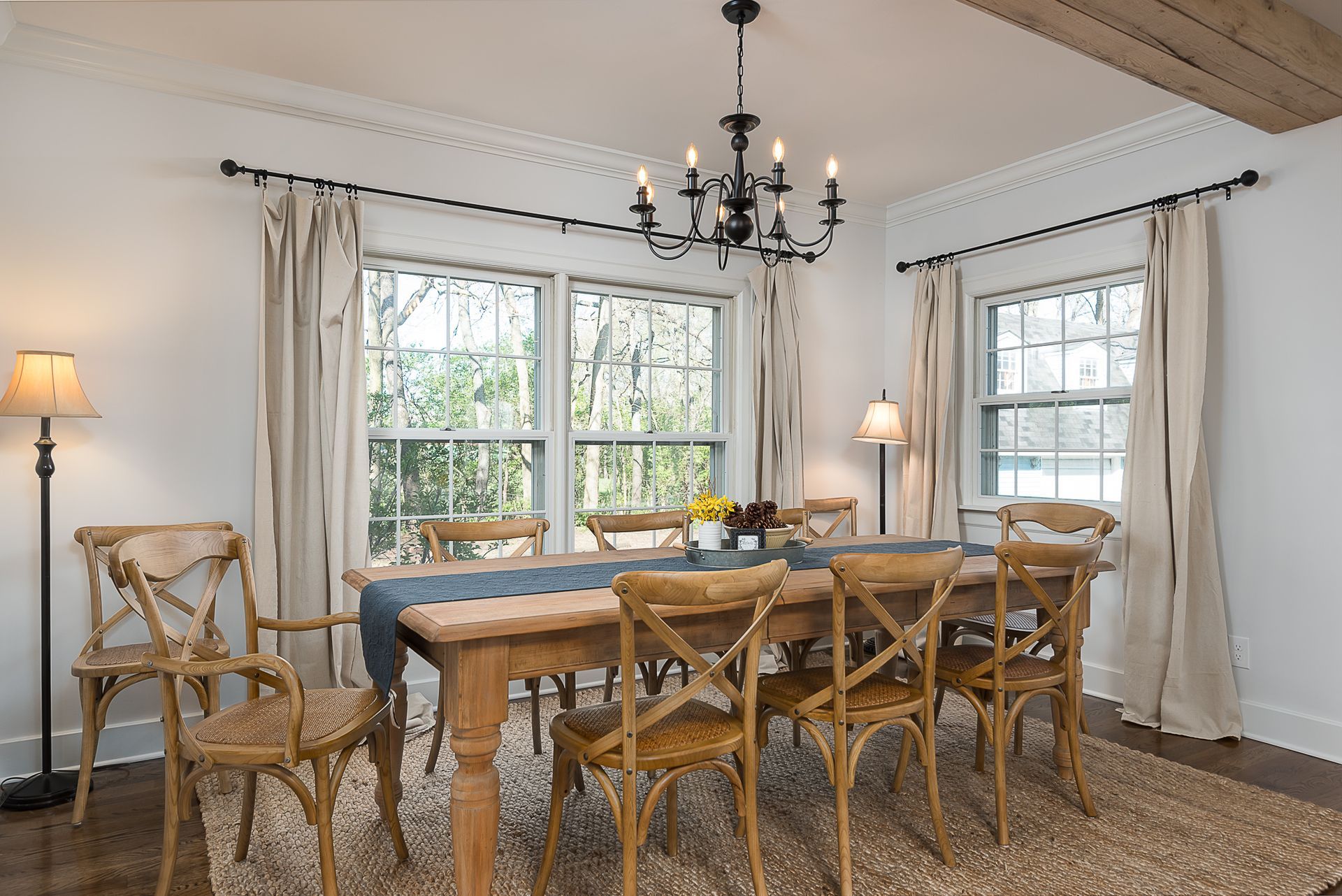 A dining room with a table and chairs and a chandelier hanging from the ceiling.