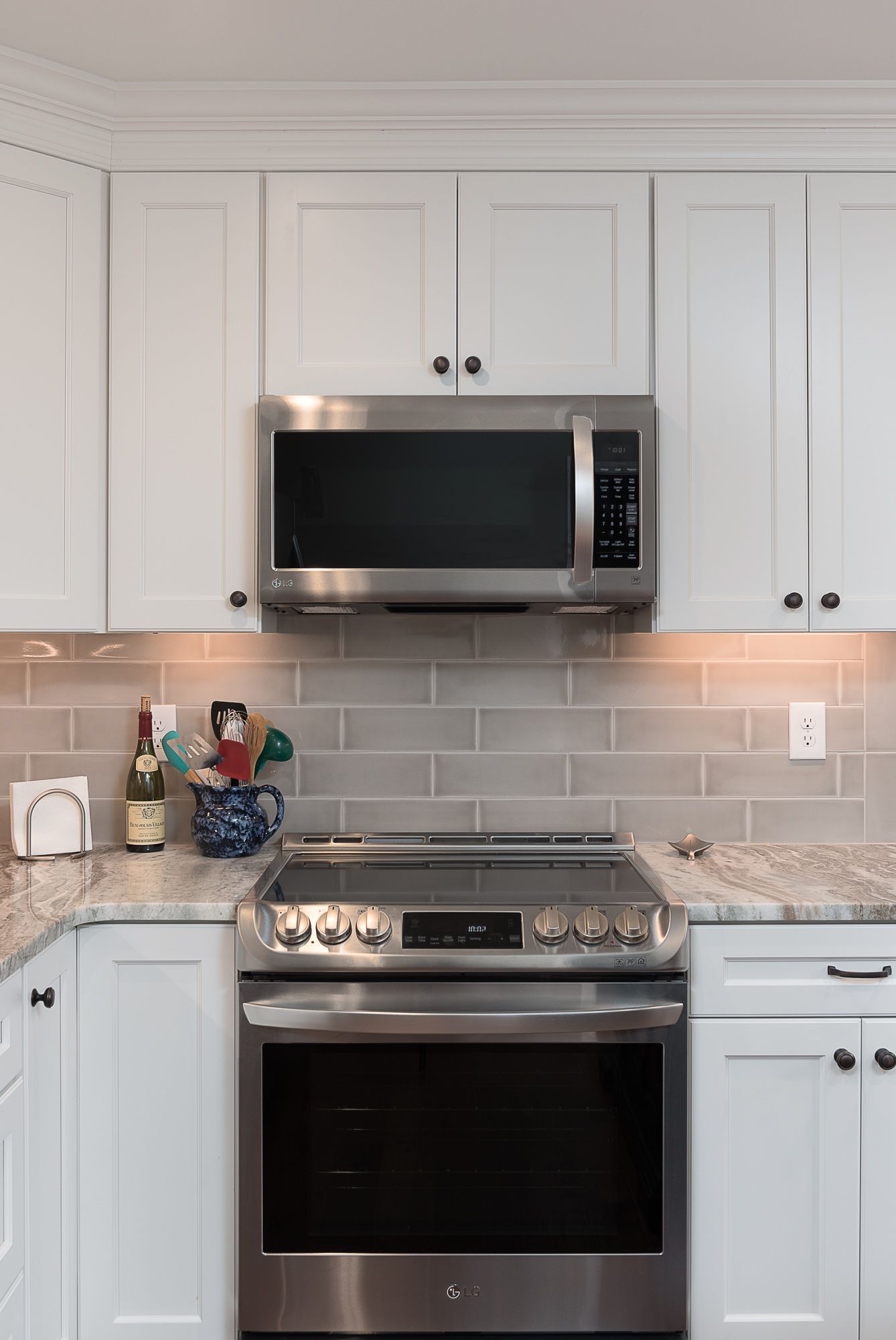 A kitchen with stainless steel appliances and white cabinets.