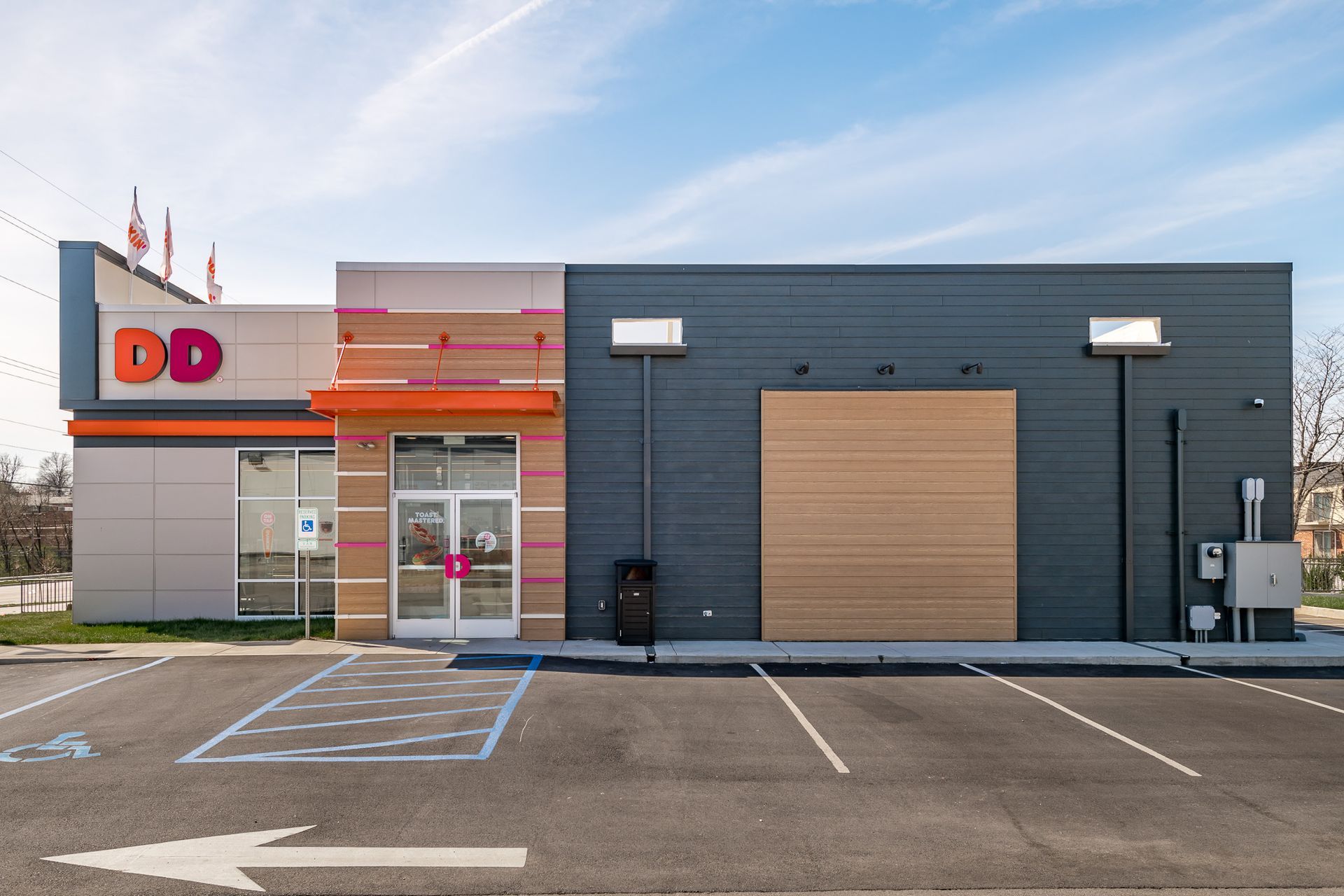 A dunkin donuts restaurant with a parking lot in front of it
