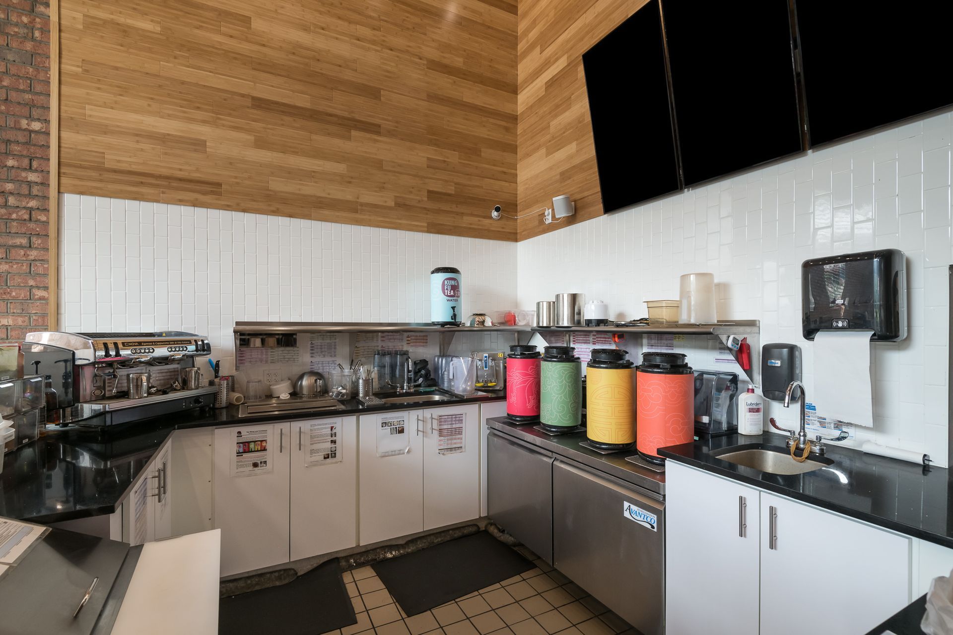 A kitchen with stainless steel appliances , white cabinets , a sink , and a stove.