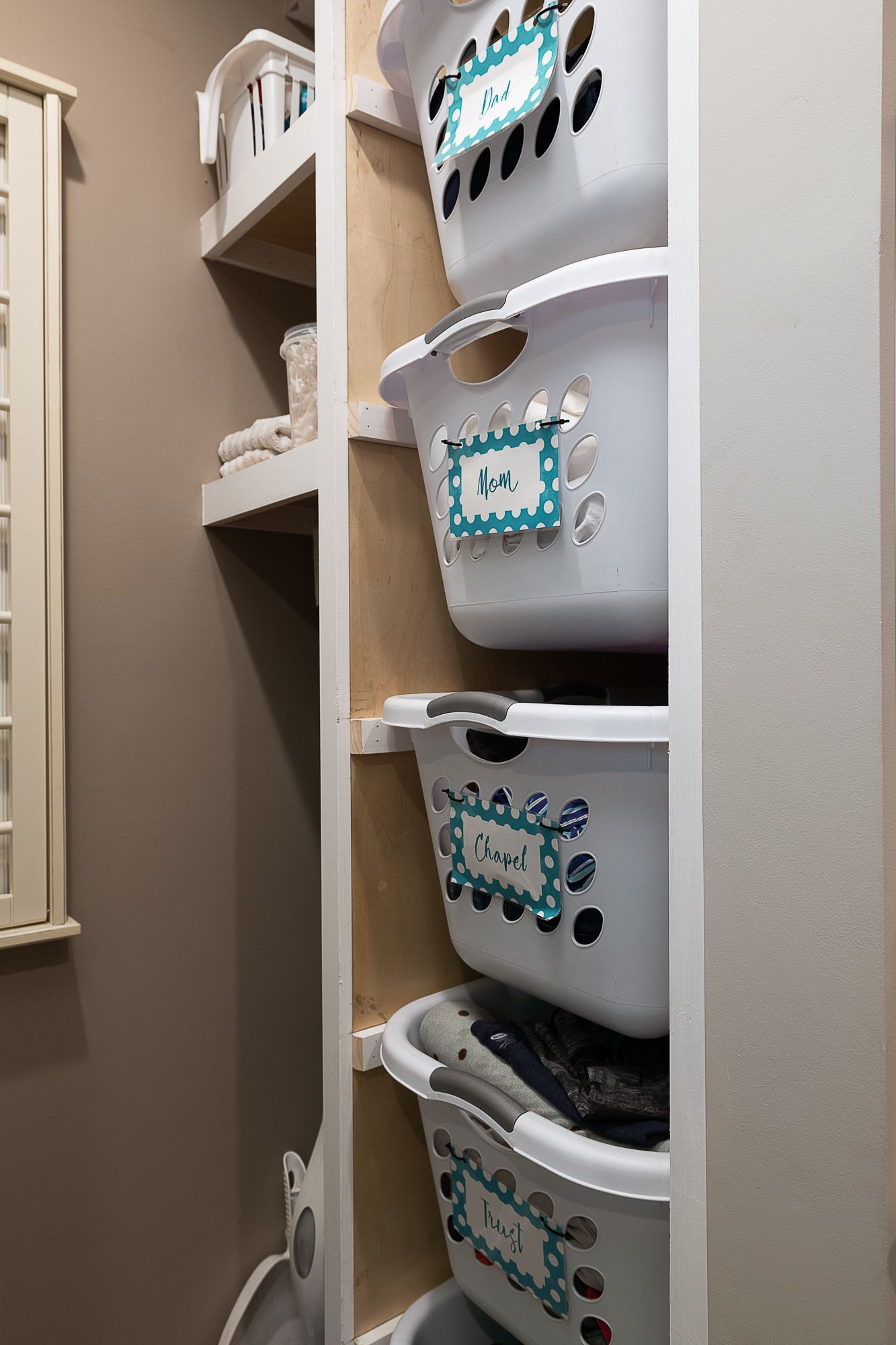 Three laundry baskets are stacked on top of each other in a closet.