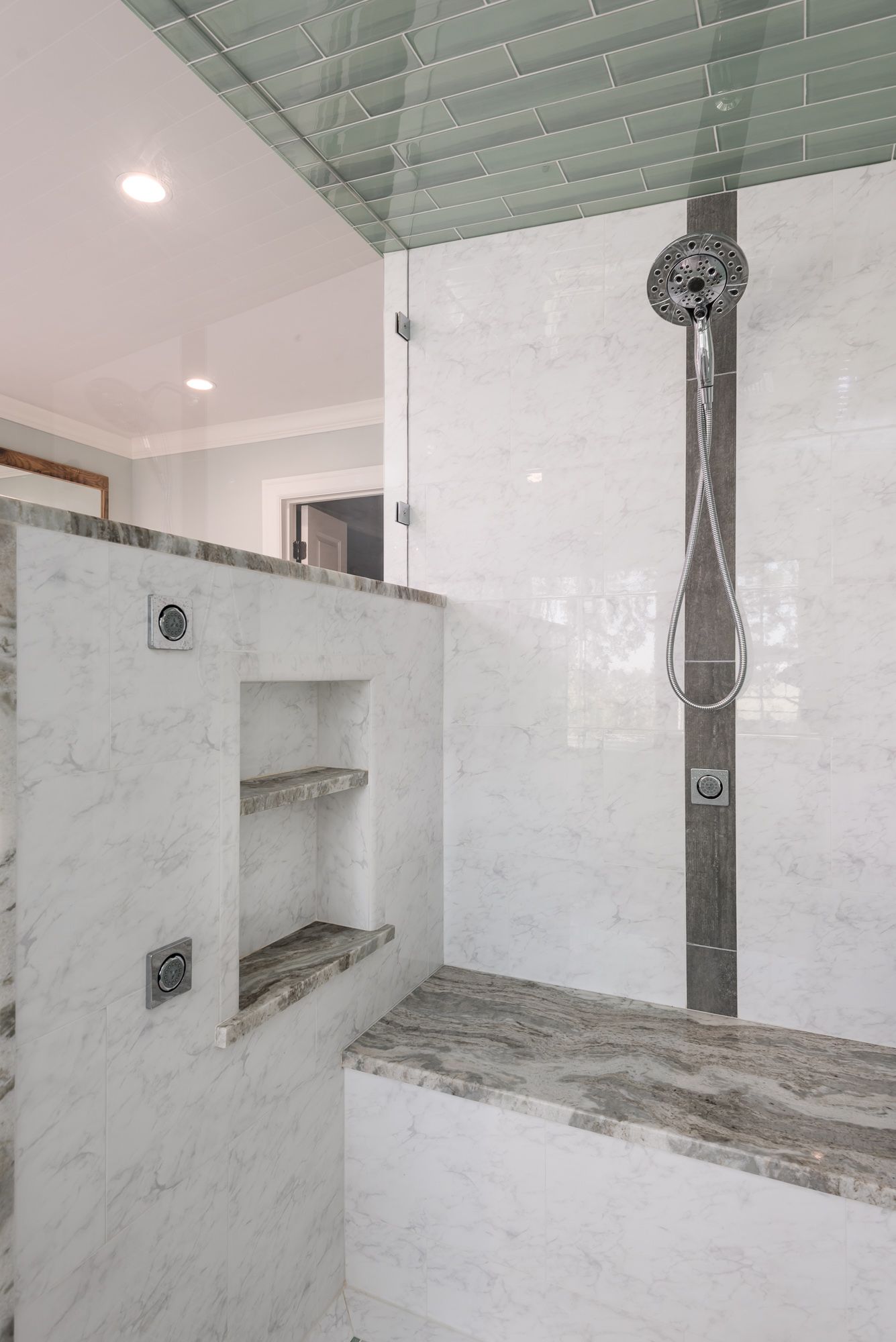 A bathroom with a walk in shower and a bench.