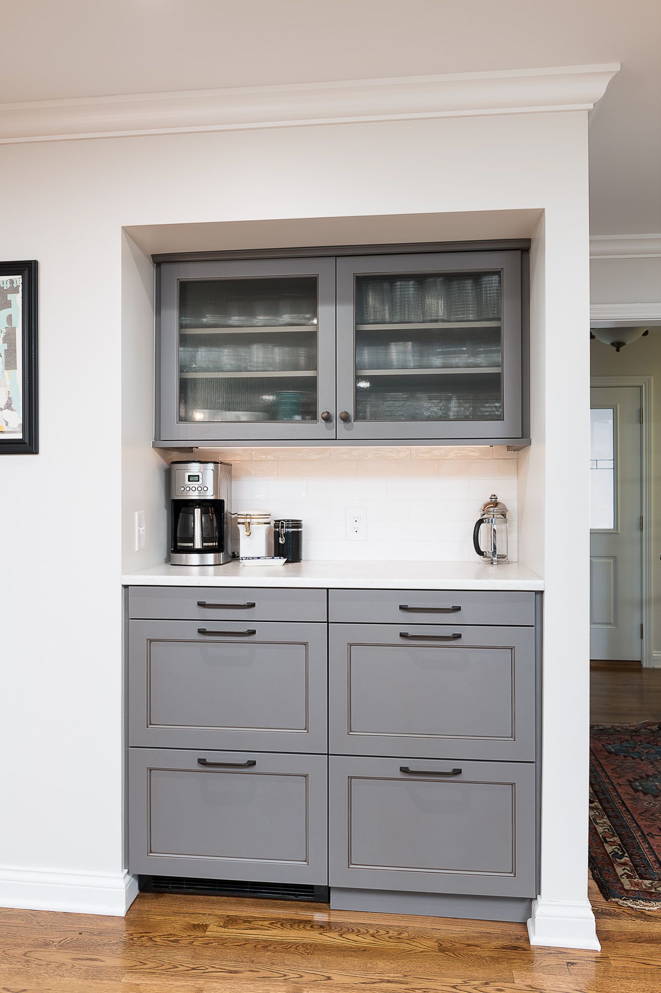 A kitchen with gray cabinets and a coffee maker