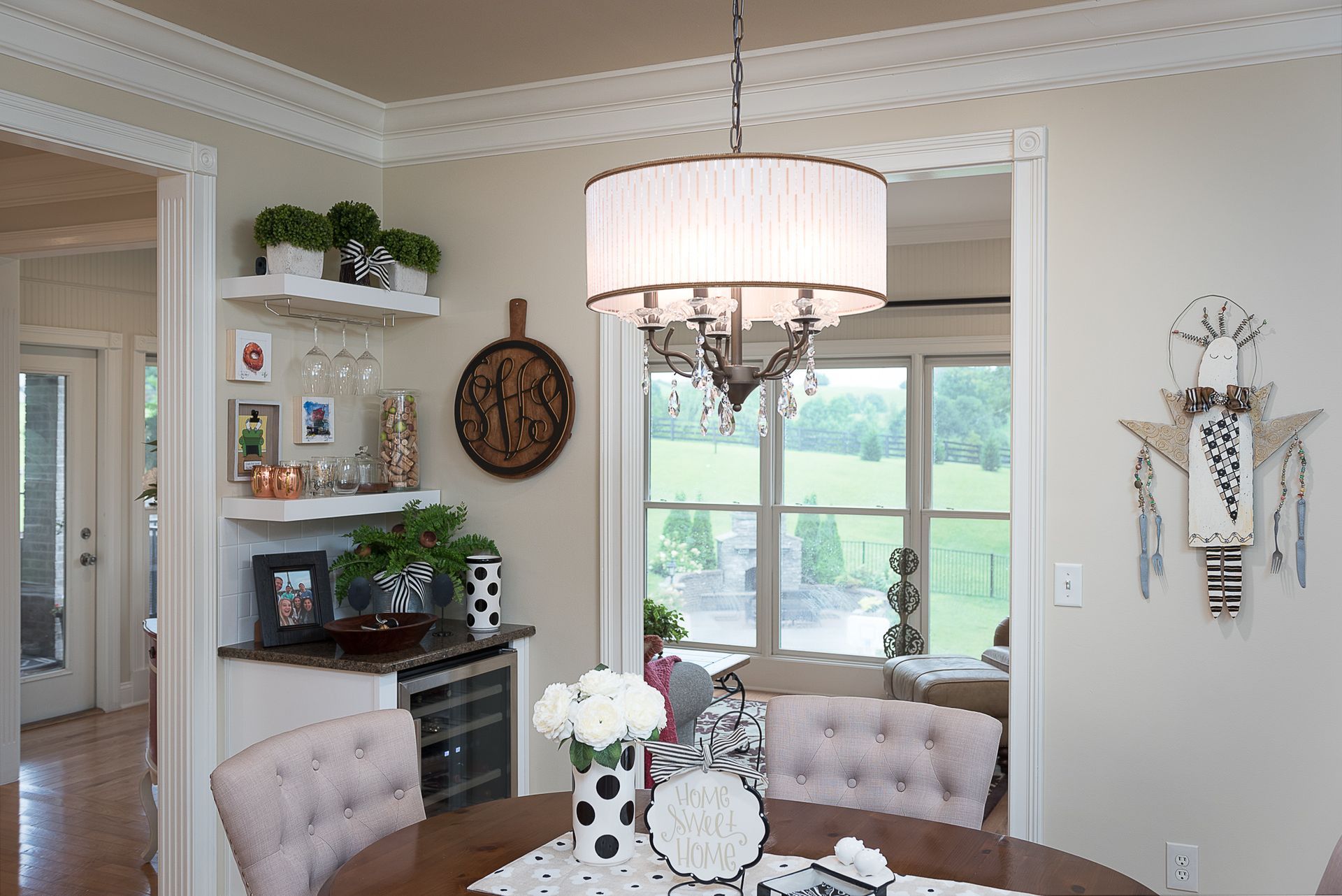 A dining room with a table and chairs and a chandelier hanging from the ceiling.