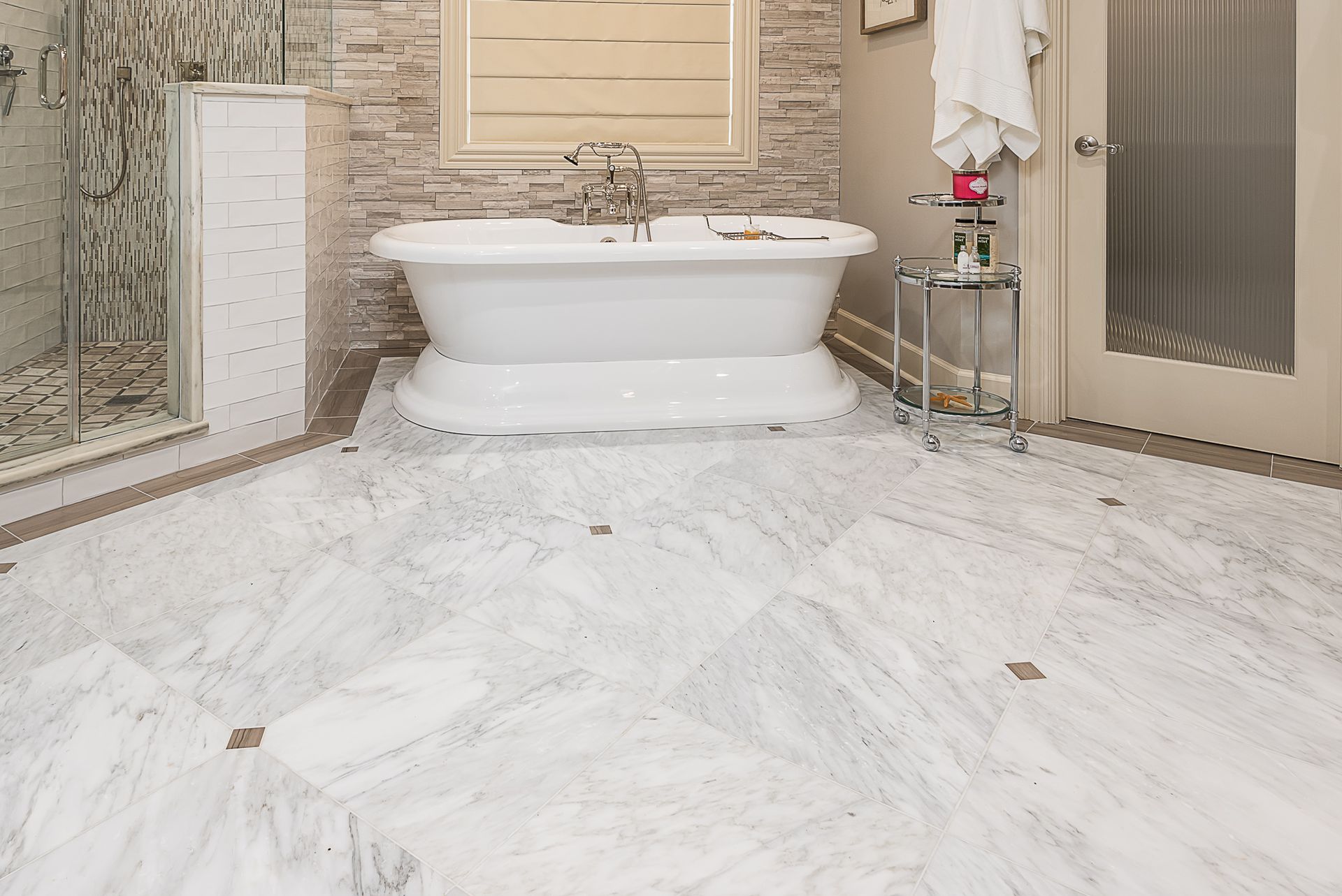 A bathroom with a bathtub and a marble floor