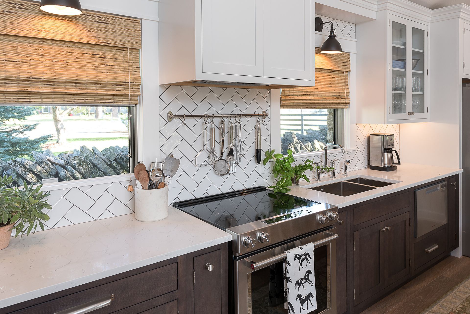 A kitchen with stainless steel appliances , a stove , a sink , and a window.