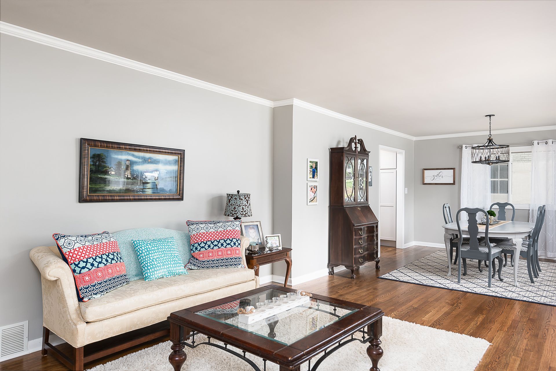 A living room with a couch , coffee table , dining table and chairs.