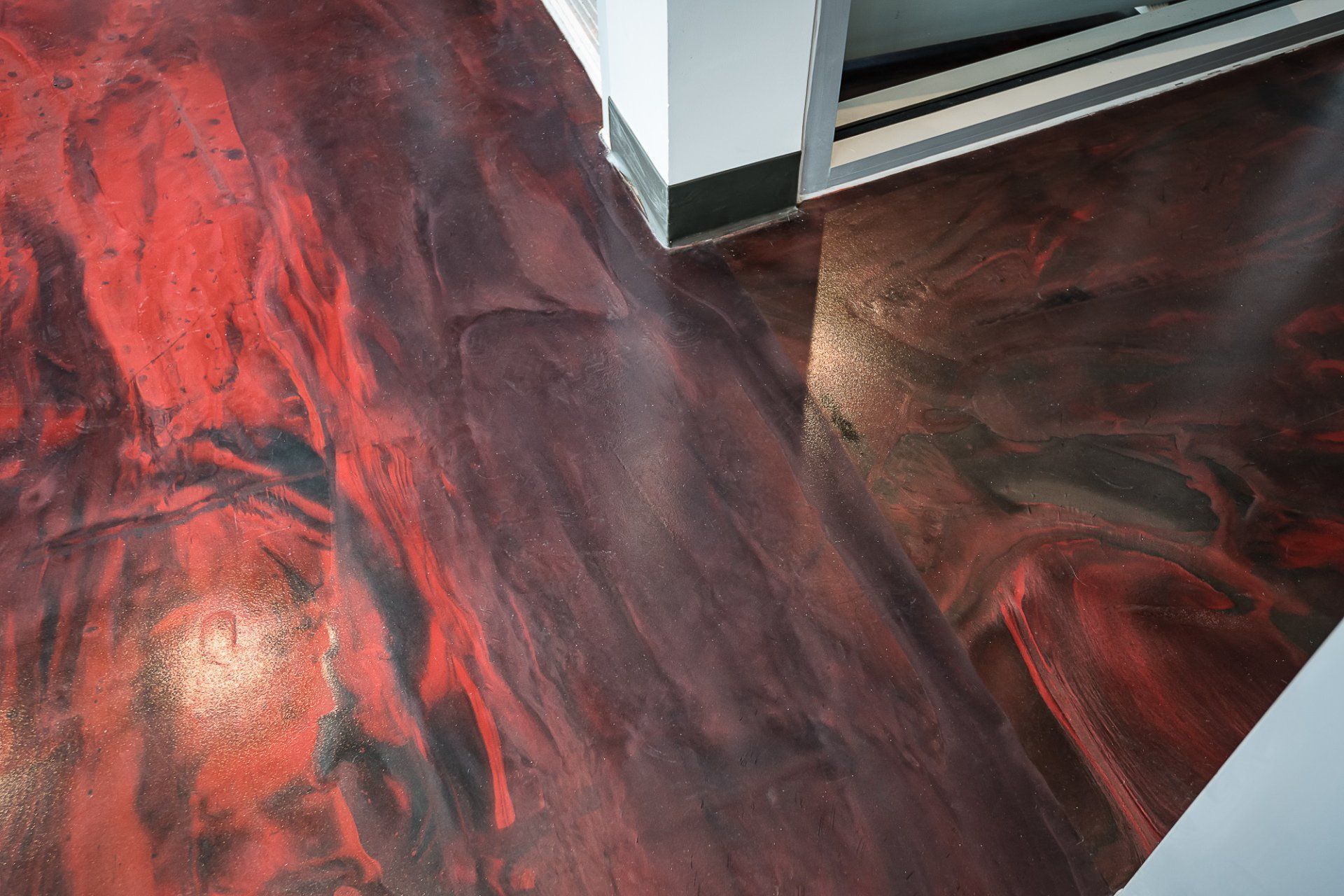 A close up of a red and black floor in a room.