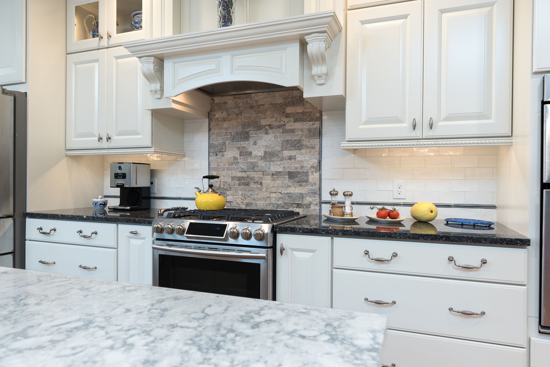 A kitchen with white cabinets and stainless steel appliances