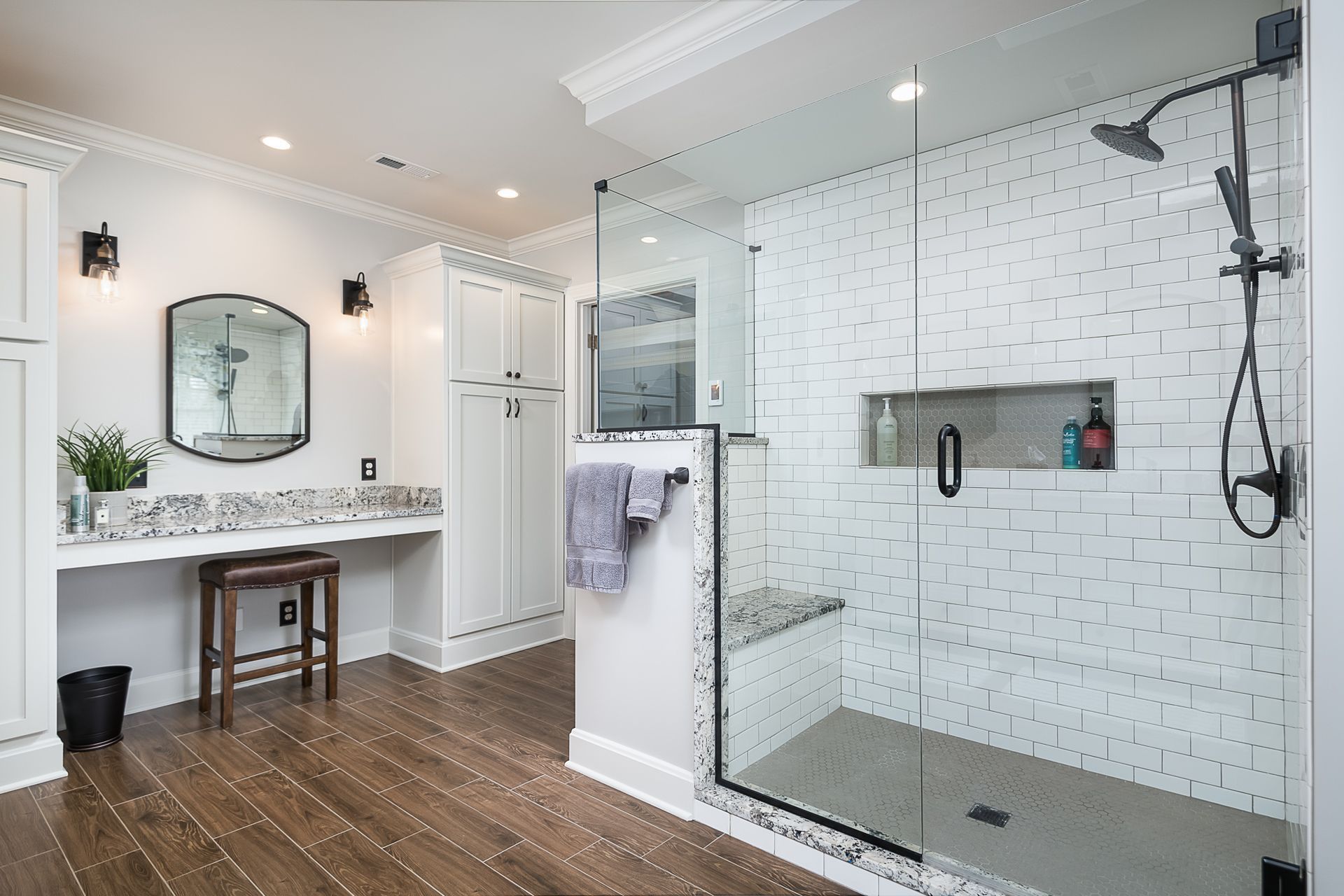 A bathroom with a walk in shower and a vanity.