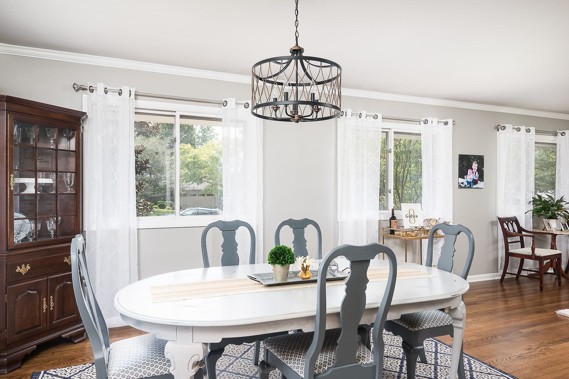 A dining room with a table and chairs and a chandelier hanging from the ceiling.
