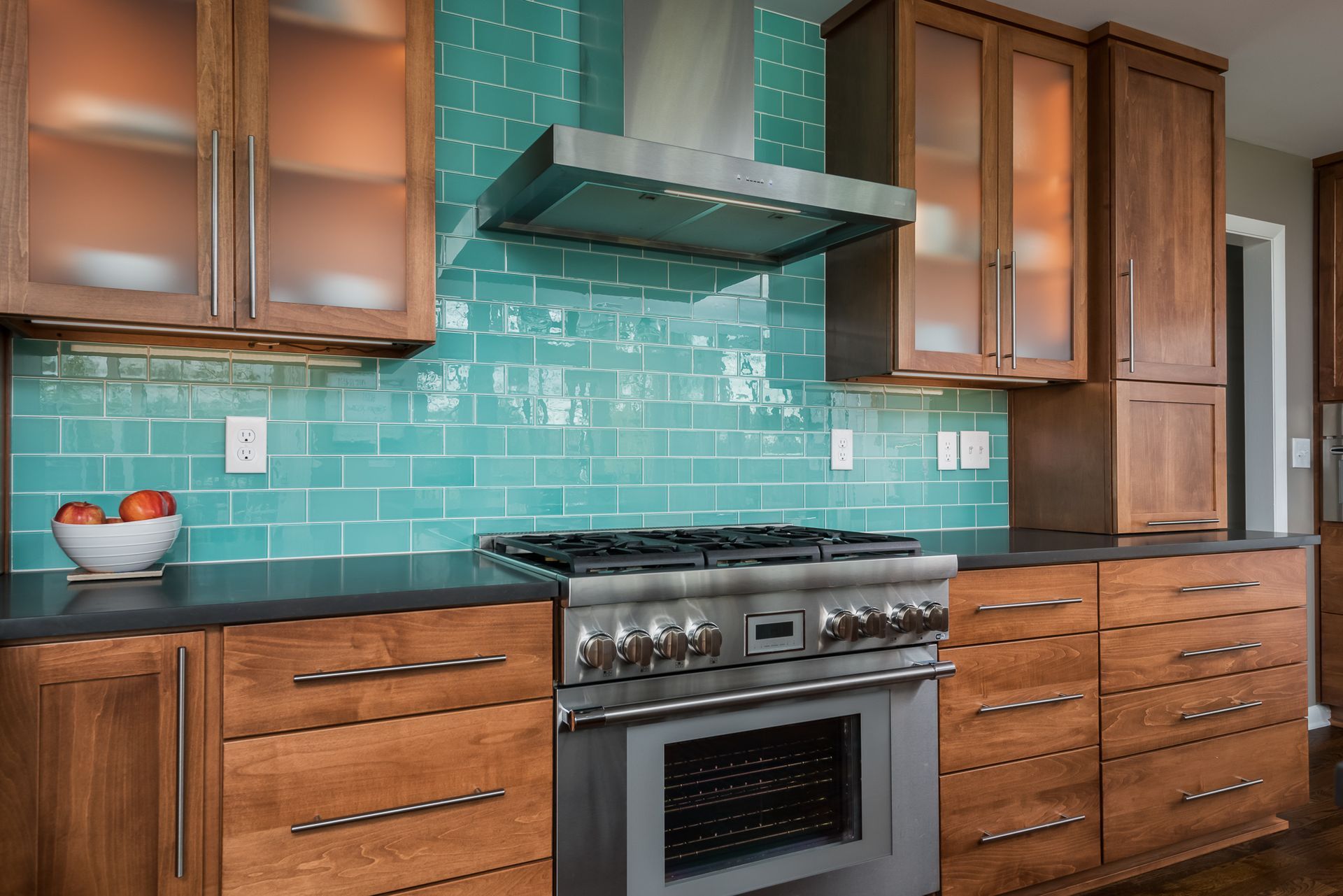 A kitchen with wooden cabinets , a stove , and a hood.