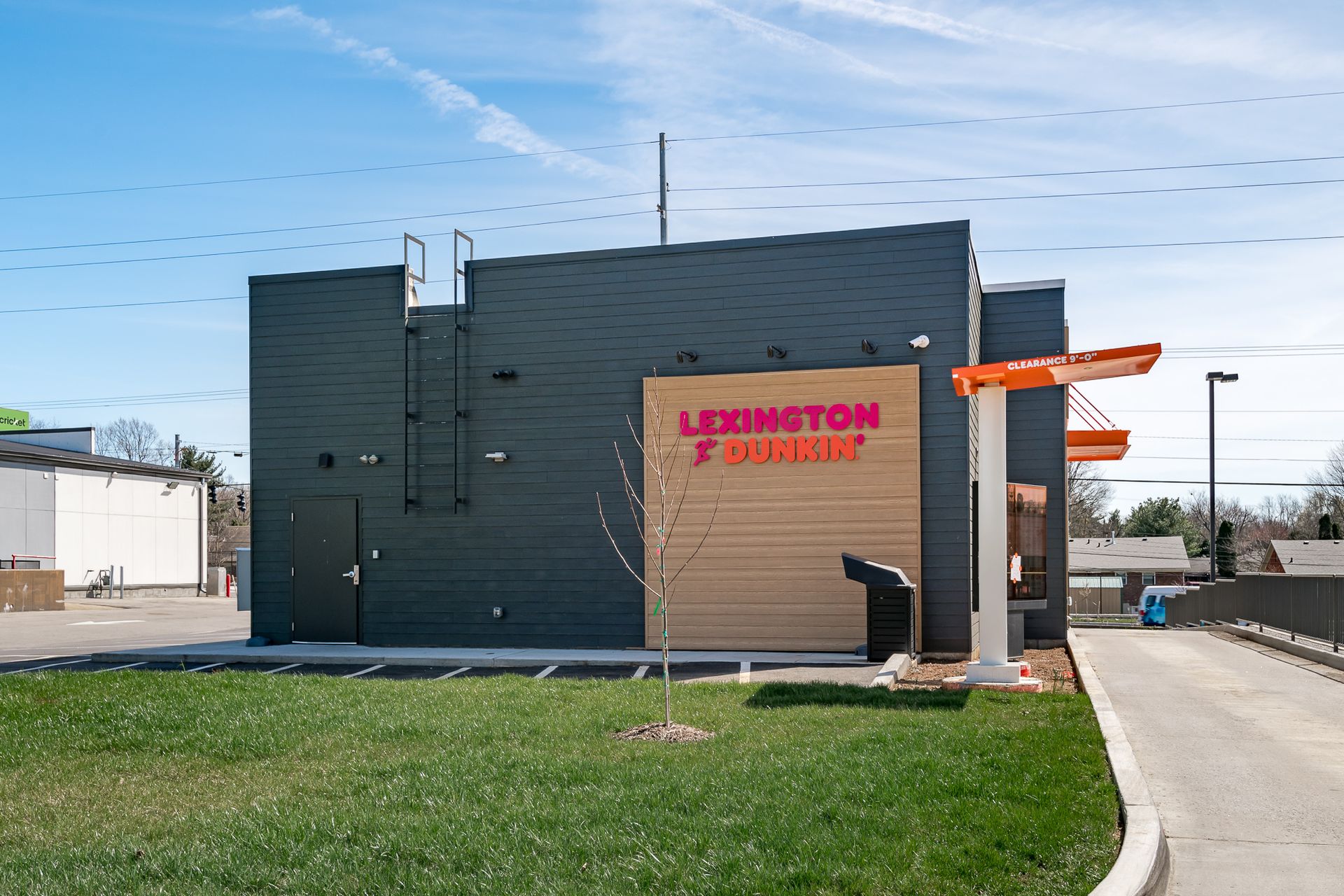A dunkin donuts restaurant with a ladder on the side of it